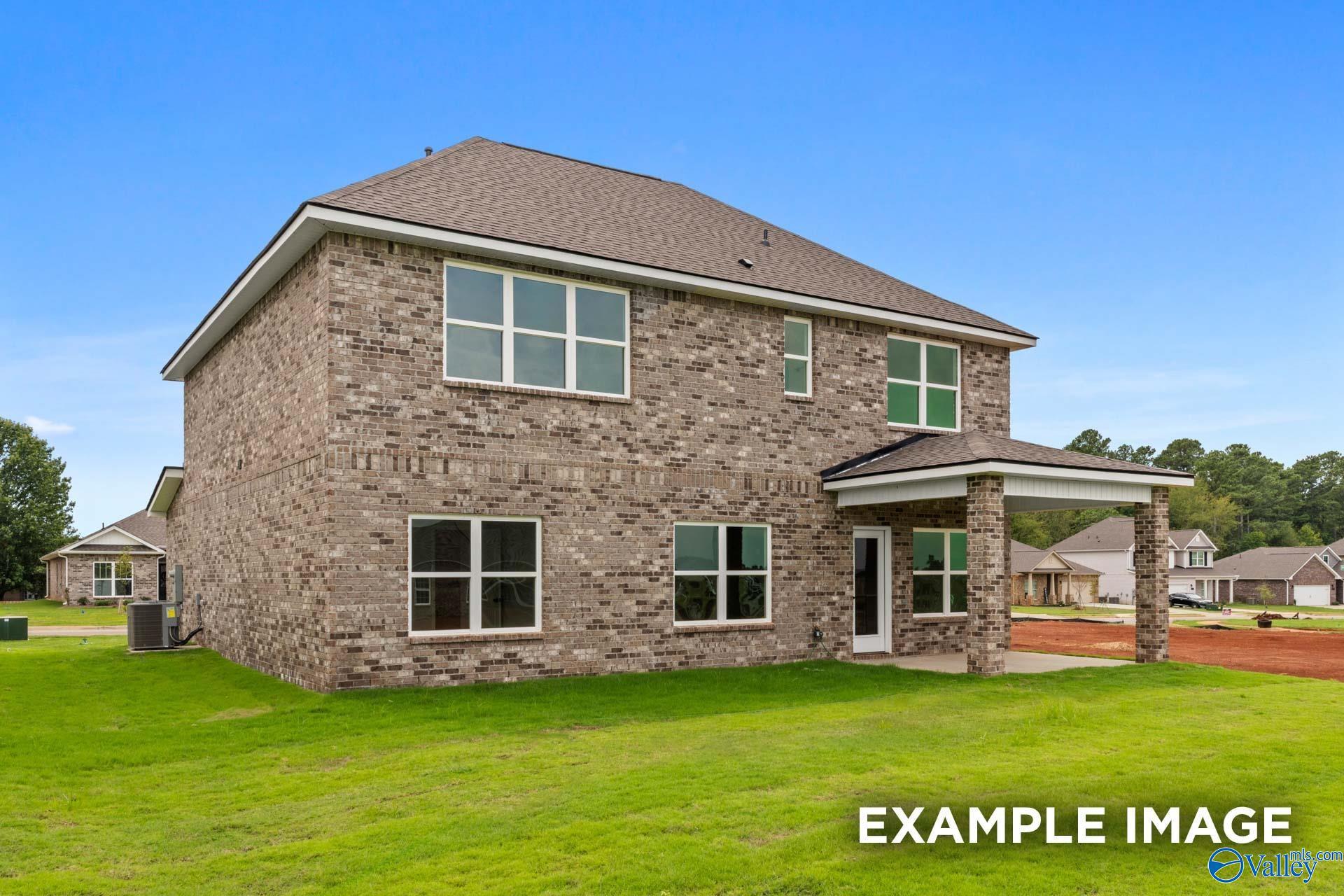 Two-story brick home rear exterior with covered patio in Jaguar Hills, Huntsville, Alabama by Davidson Homes.