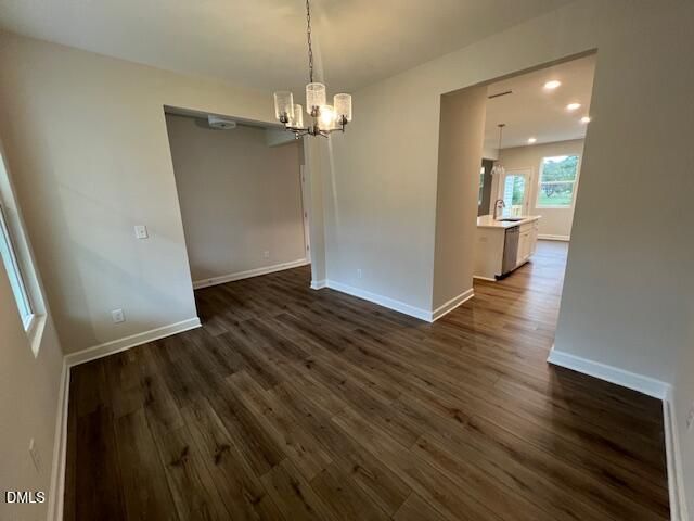 Bright dining room with wood-look flooring and chandelier in Davidson Homes The Willow D floor plan, Lillington, NC