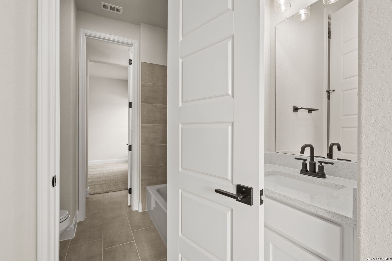 Modern bathroom with white vanity and matte black fixtures in The Summerlin B floor plan by Davidson Homes in Castroville.
