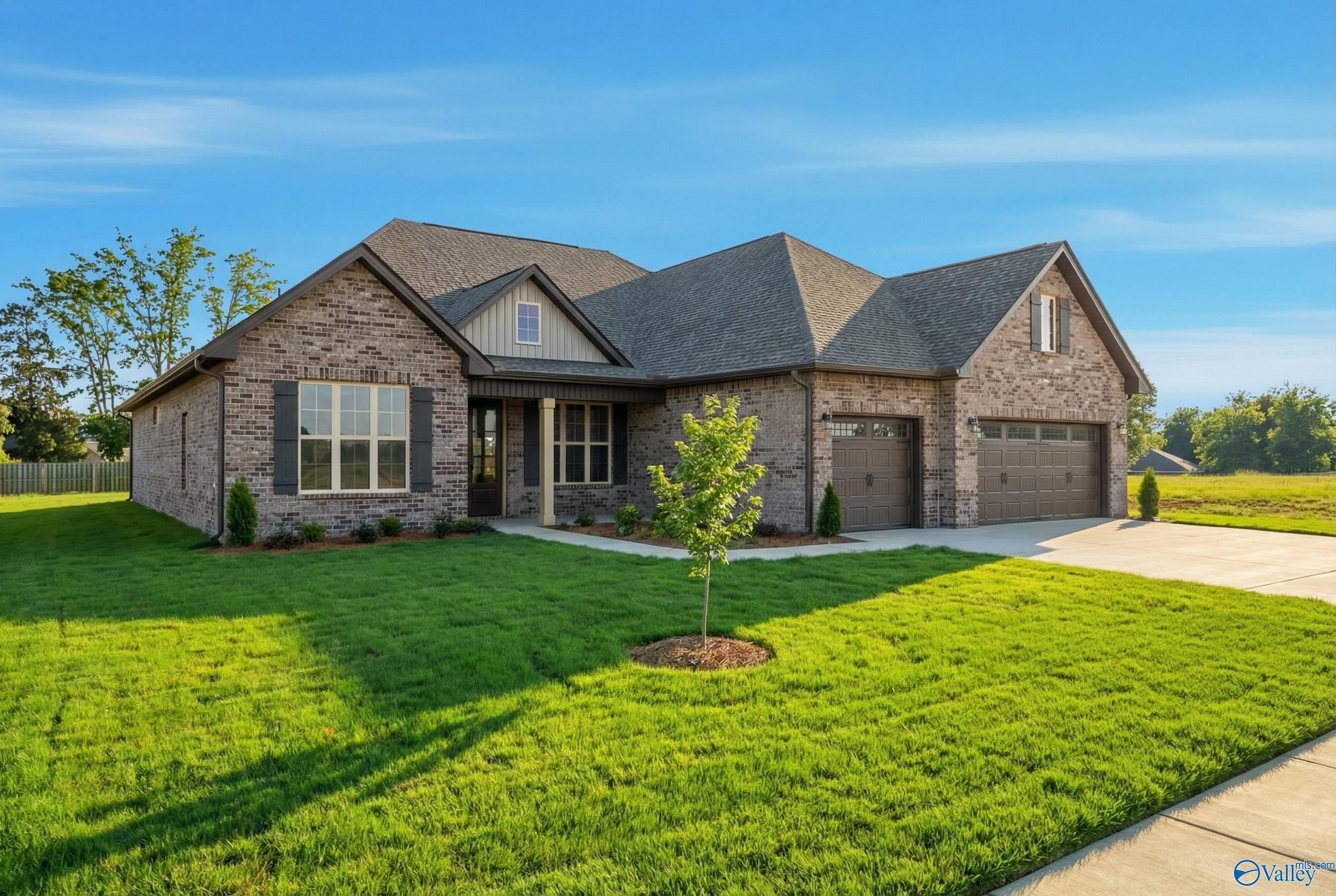 Single-story brick ranch home with 3-car garage, gabled roof, and lush front yard in Briercreek, Meridianville, Alabama