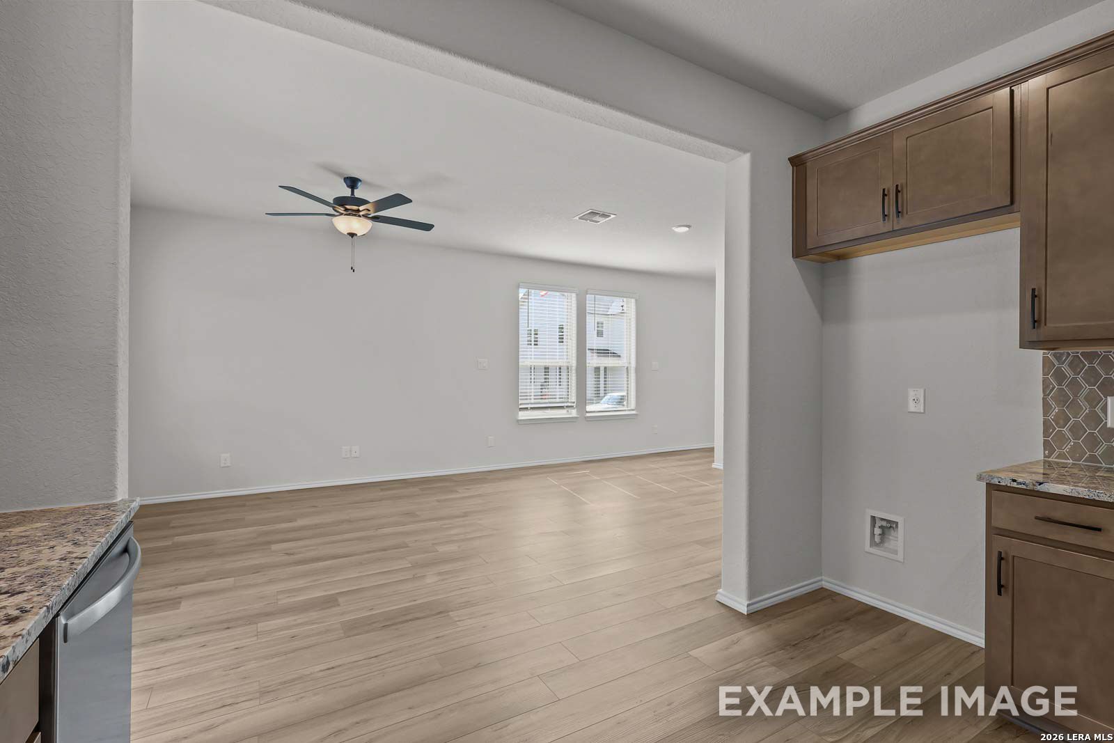 Open-concept living area with light wood floors in The Florence D floor plan at Cedar Heights, San Antonio.