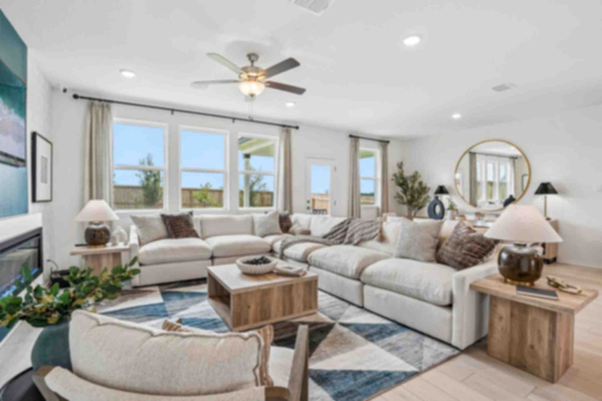 Open-concept kitchen and living room at Morgan Meadows in San Antonio Texas by Davidson Homes with hardwood floors brick accent wall and leather sofa