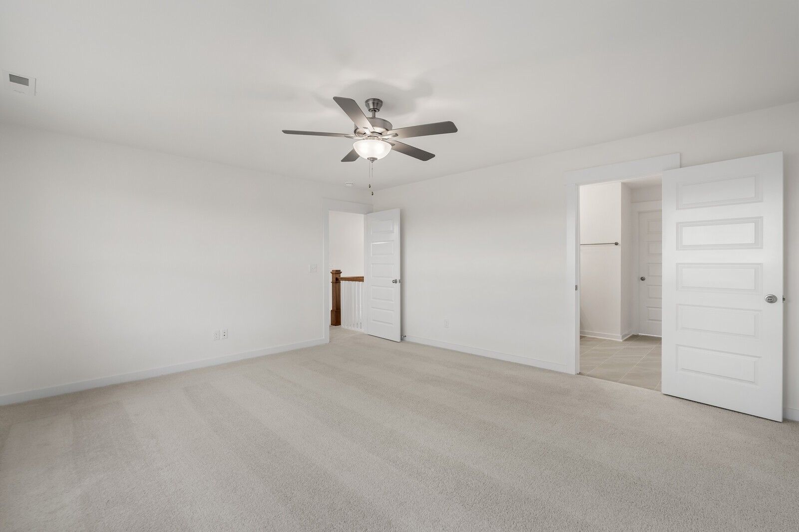 Spacious bedroom with ceiling fan, open closet doors, and en-suite bath in Davidson Homes The Willow C, Gallatin, TN