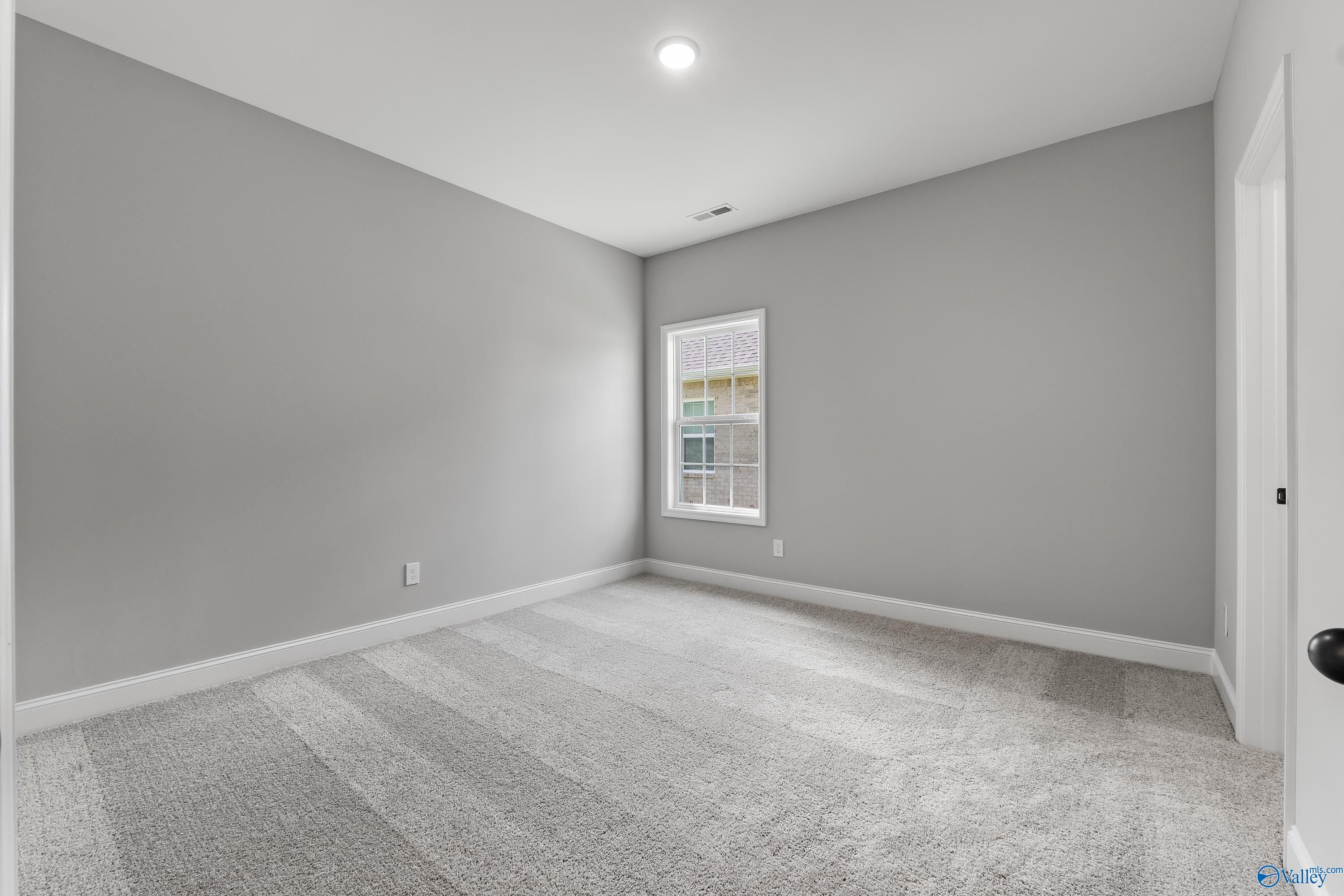 Spacious empty bedroom with gray walls, plush carpet, and window in 4-bedroom Montgomery B With Bonus home, Toney, Alabama