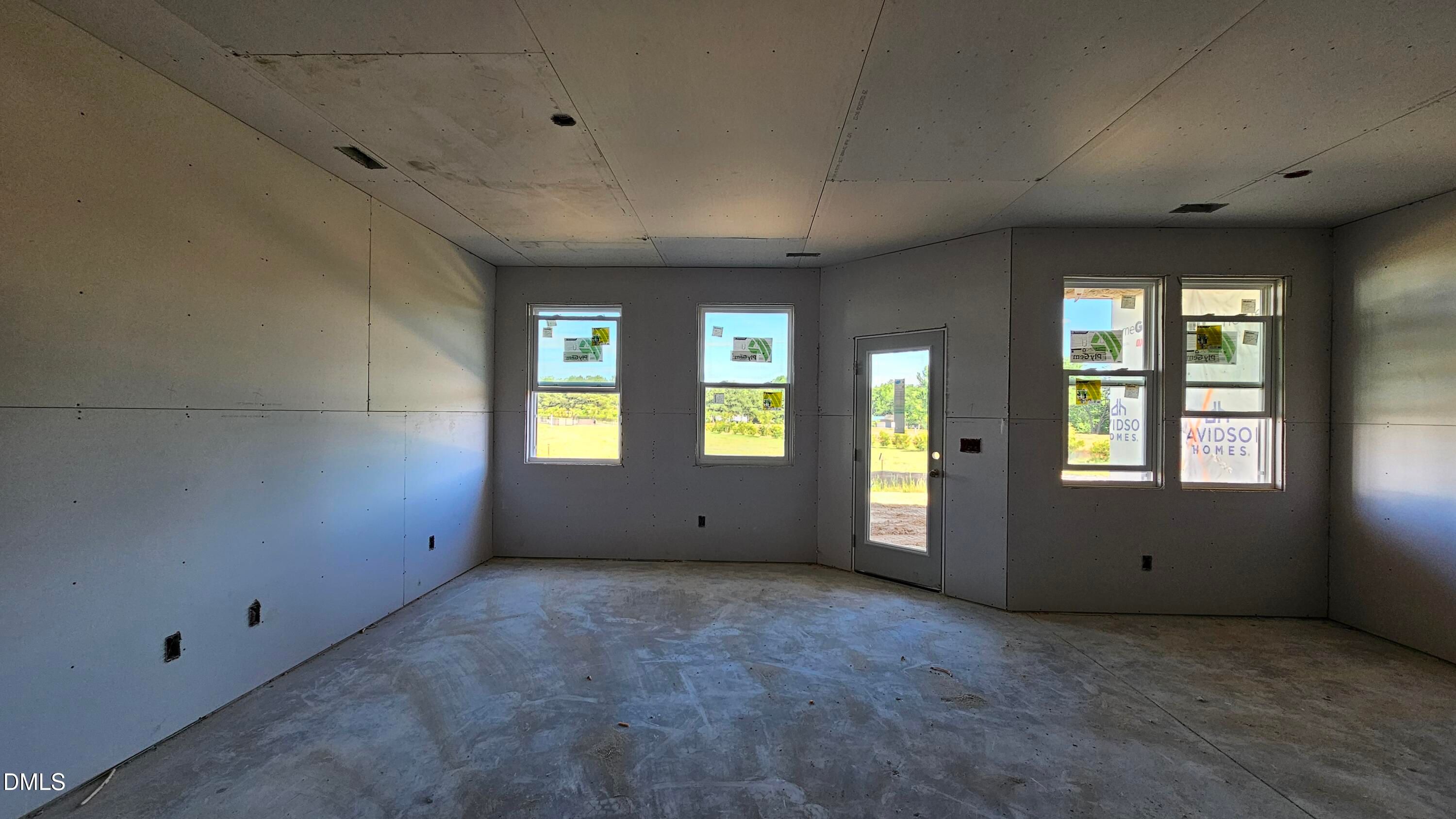 Unfinished living area with drywall and natural light in The Graham floor plan by Davidson Homes in Springvale, Fuquay-Varina.