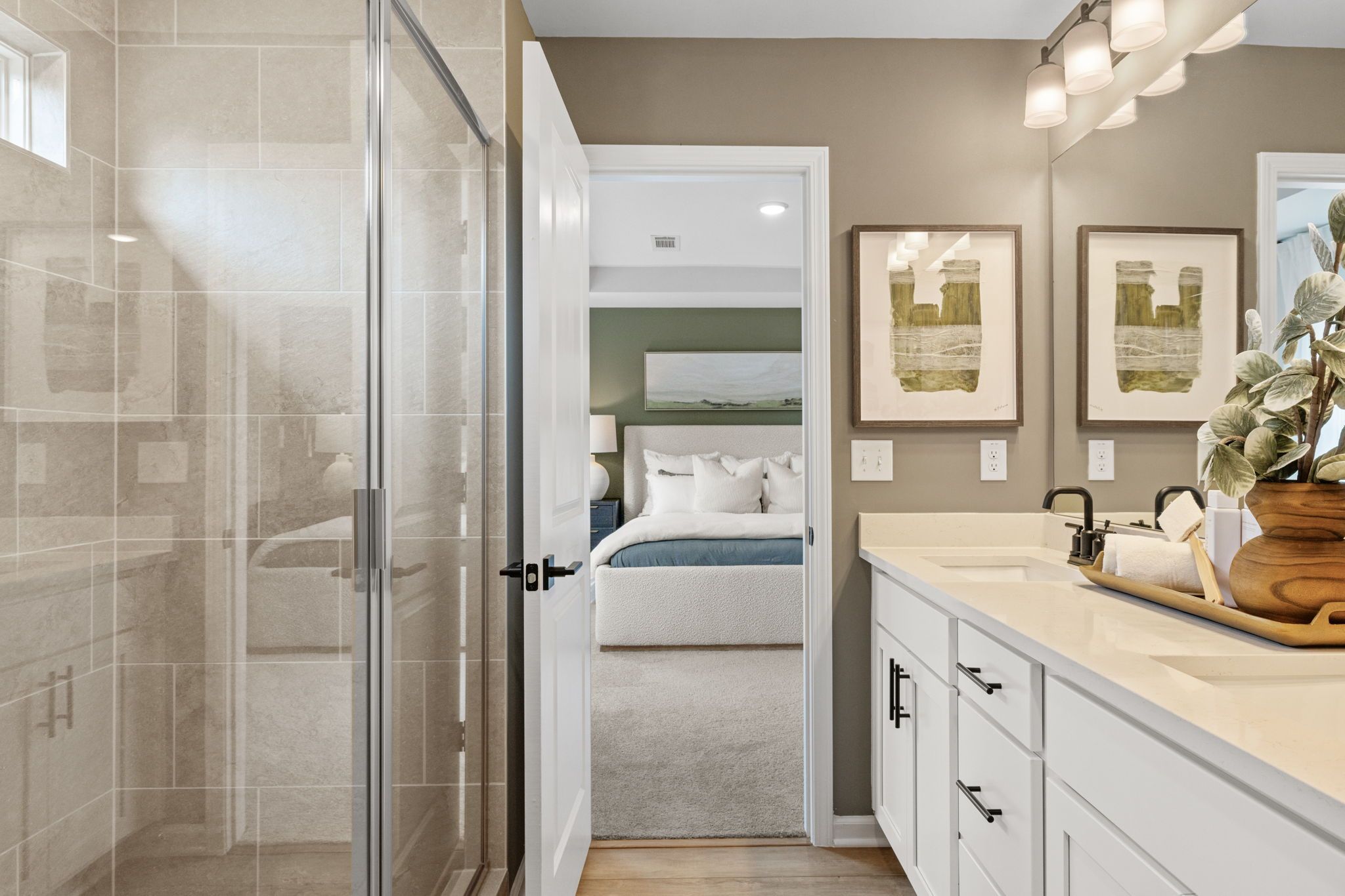 Spacious master bathroom in Cedar Farms Winder GA featuring frameless glass shower, double quartz vanity, and open view to bedroom