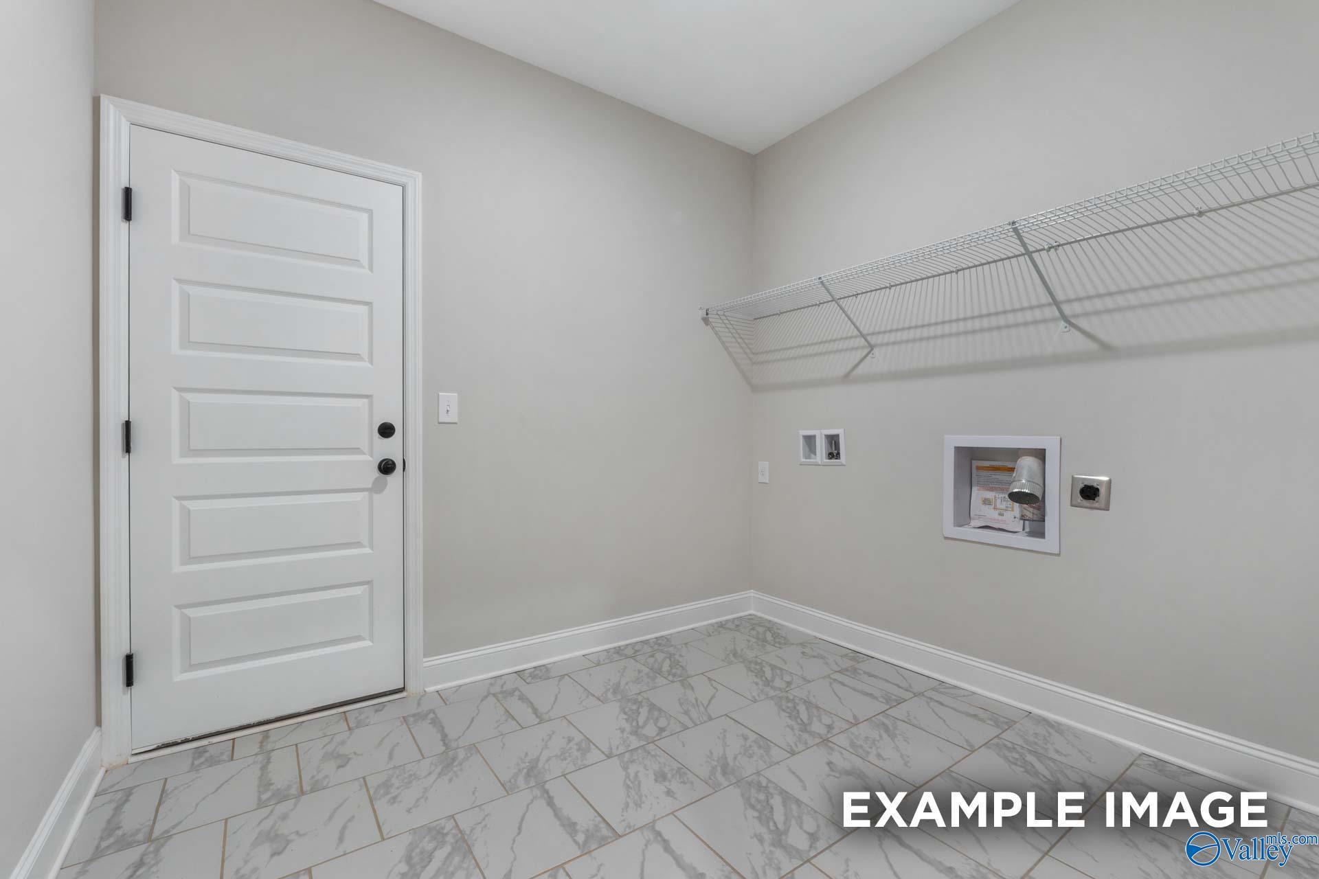 Modern laundry room with wire shelving, washer/dryer hookups, and gray tile floor in Davidson Homes The Finleigh, Meridianville, Alabama