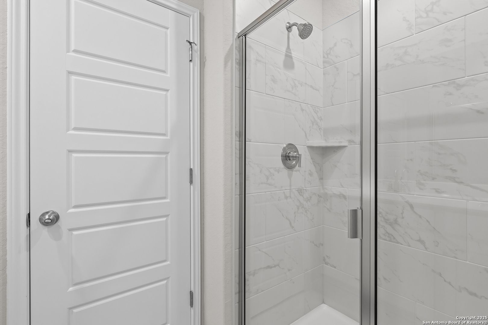 Modern master bathroom with frameless glass shower, white subway tiles, and chrome fixtures in Davidson Homes The Colorado B, San Antonio
