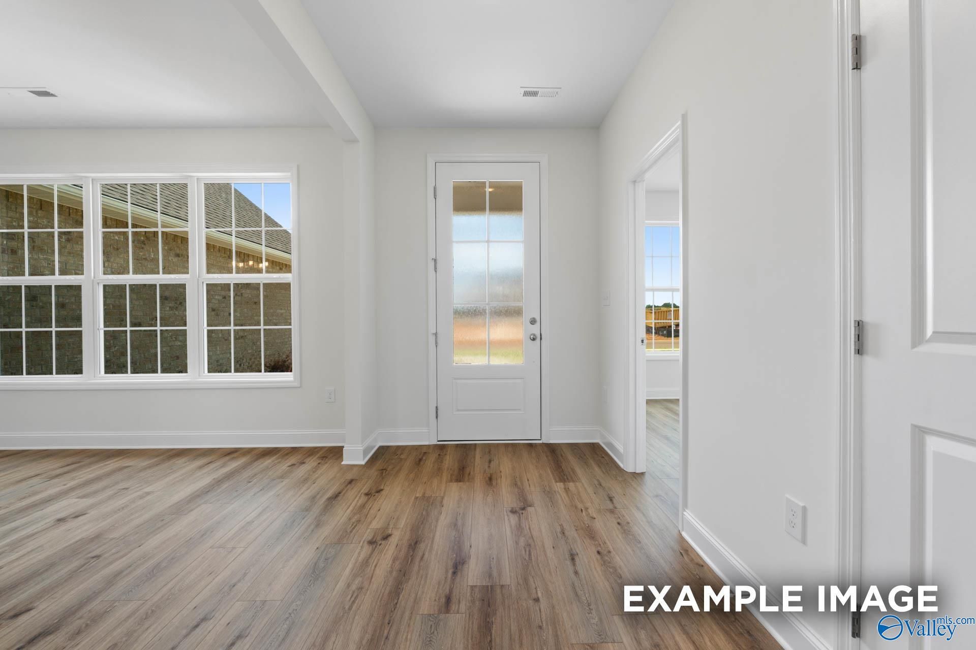 Bright entryway with hardwood floors, large windows, and glass French doors in Davidson Homes The Oxford, Huntsville, Alabama
