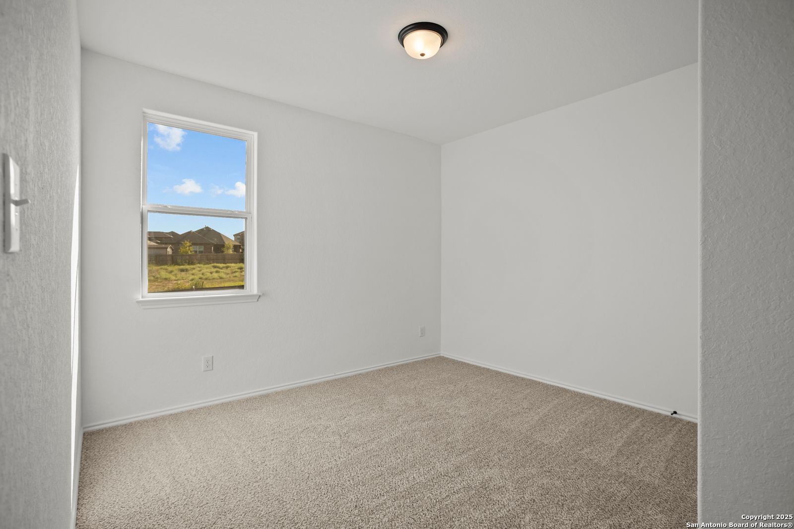 Bright empty bedroom with large window and field view in The Daphne K floor plan, Davidson Homes, San Antonio