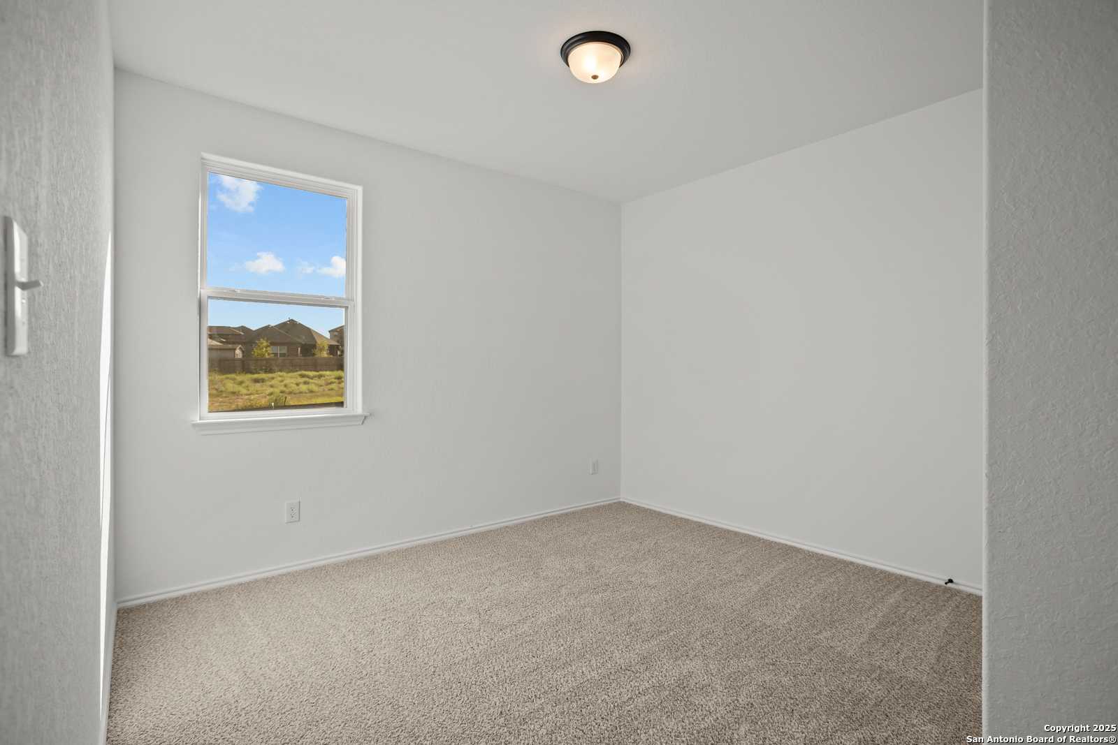 Bright empty bedroom with large window and field view in The Daphne K floor plan, Davidson Homes, San Antonio