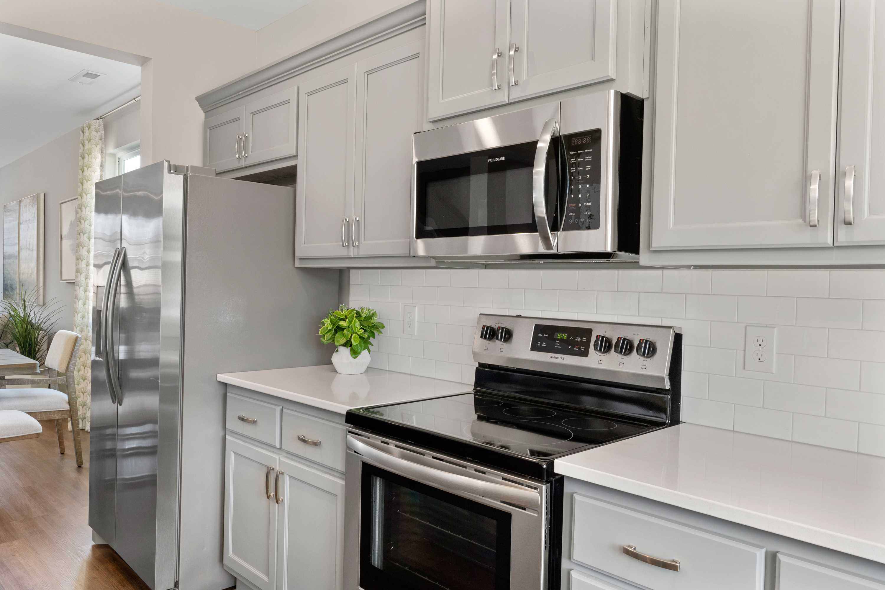 Modern kitchen at Evergreen Mill in Madison Alabama with white shaker cabinets, stainless steel appliances, and subway tile backsplash