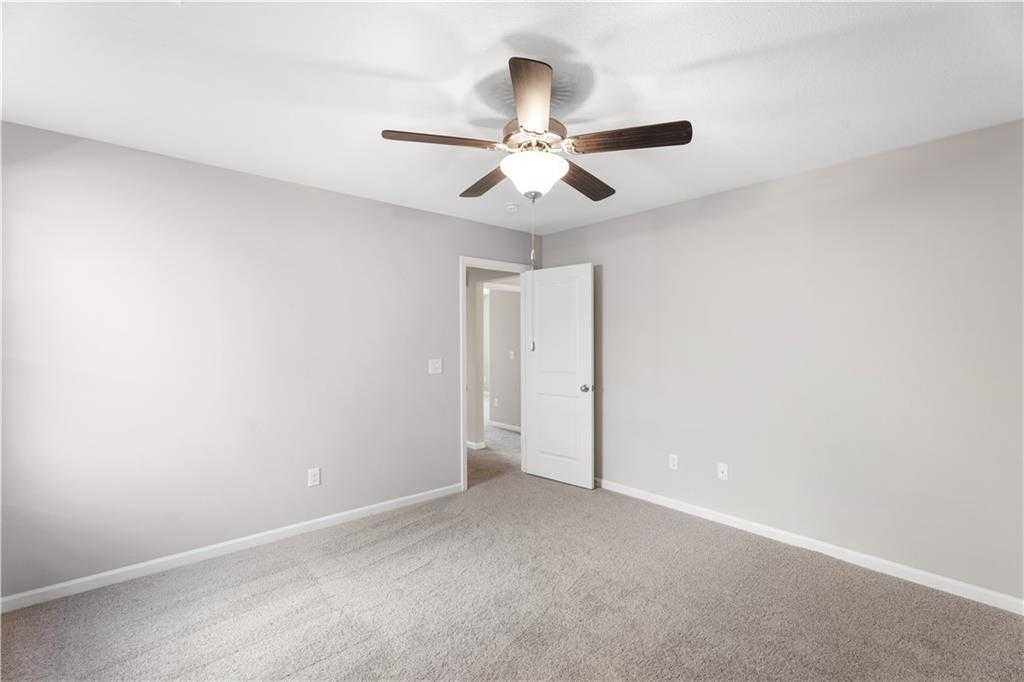 Bright secondary bedroom with ceiling fan and open door in Davidson Homes The Washington, Phenix City, Alabama