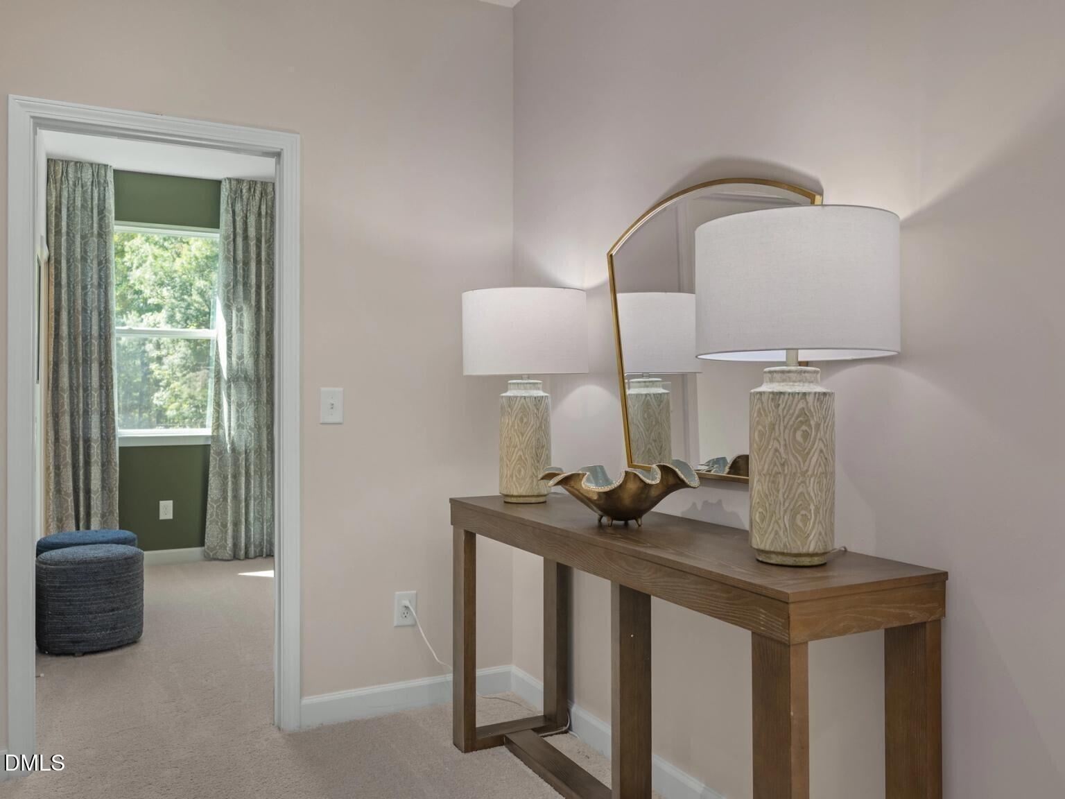 Elegant entryway with wooden console, gold arched mirror, white lamps in Davidson Homes The Hickory II D, Wake Forest, NC