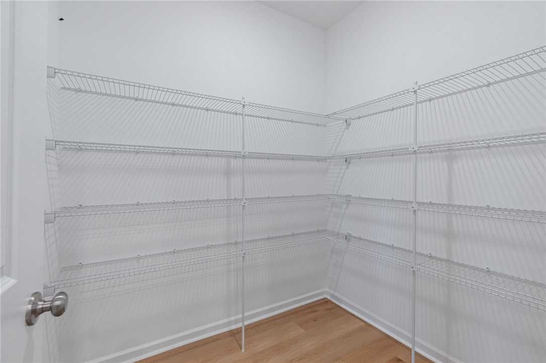 Spacious walk-in closet with white wire shelving in corner, The Luna B floor plan by Davidson Homes, Opelika Alabama