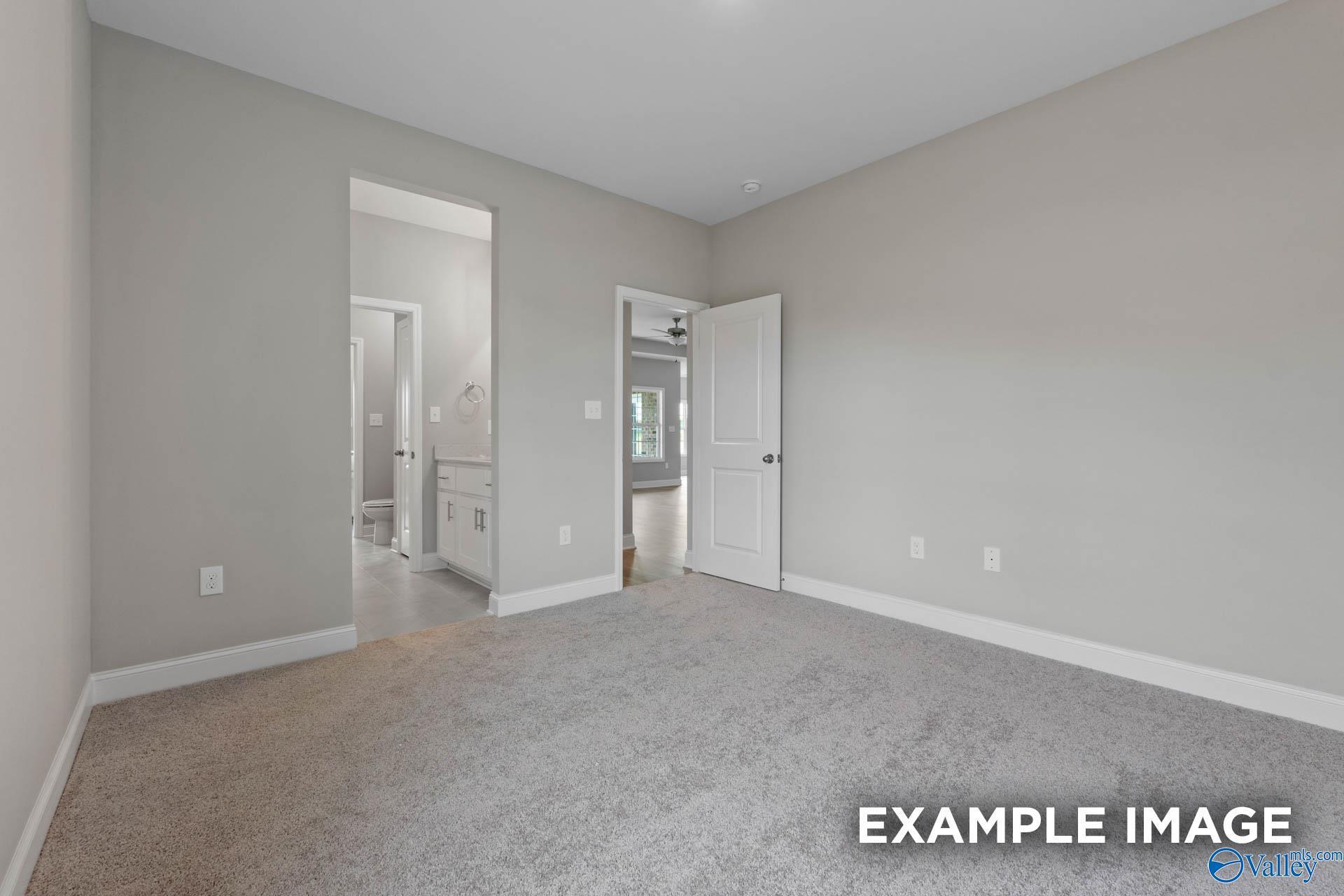Spacious bedroom with gray walls, carpeted floor, and en-suite bathroom in Davidson Homes The Finleigh, Harvest, Alabama