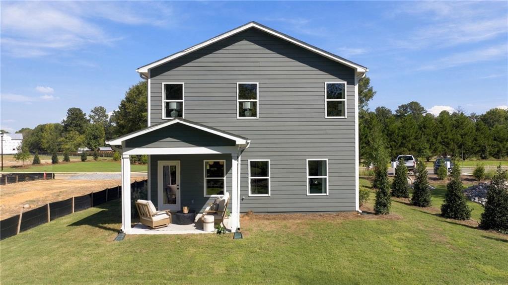 Rear exterior of Davidson Homes' The Sinclair B, a 2-story gray-sided home with covered patio and fenced yard in Greene Farm, Cartersville, GA