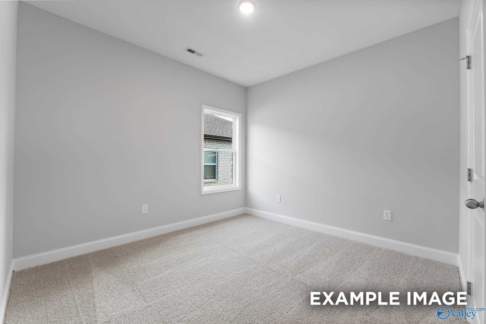 Bright secondary bedroom with light gray walls, plush carpet, and sunny window in Davidson Homes The Franklin C, Toney, Alabama