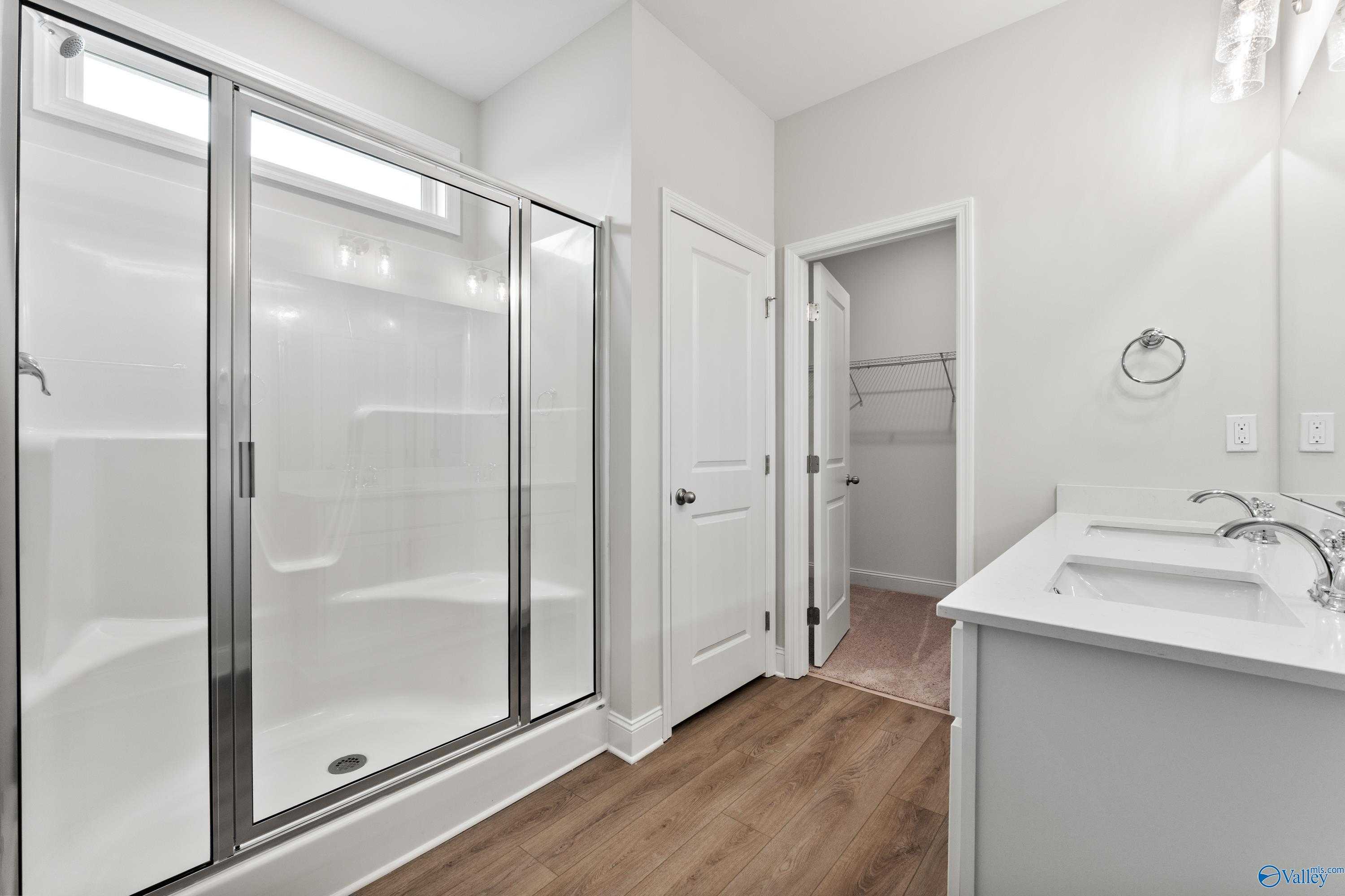 Modern master bathroom with frameless glass shower and double vanity in Davidson Homes The Franklin, Athens Alabama