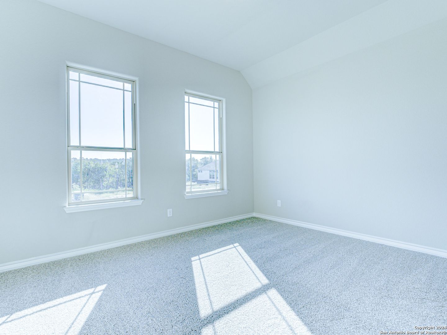 Bright empty bedroom with large windows and natural light in Davidson Homes Summerlin A, Castroville, Texas