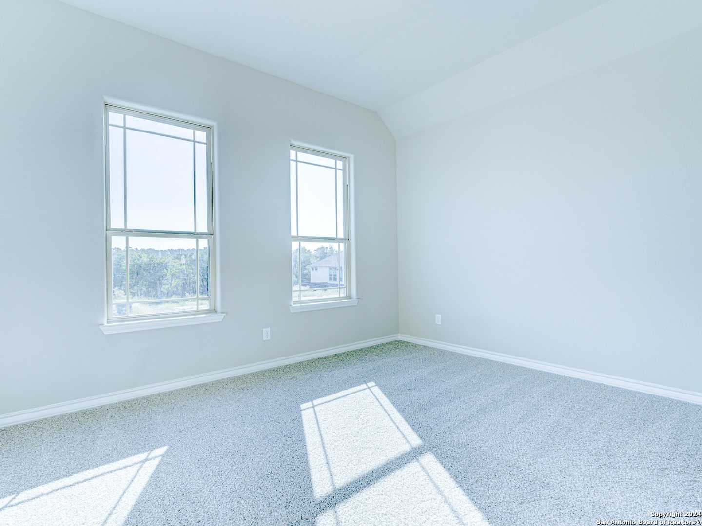 Bright empty bedroom with large windows and natural light in Davidson Homes Summerlin A, Castroville, Texas