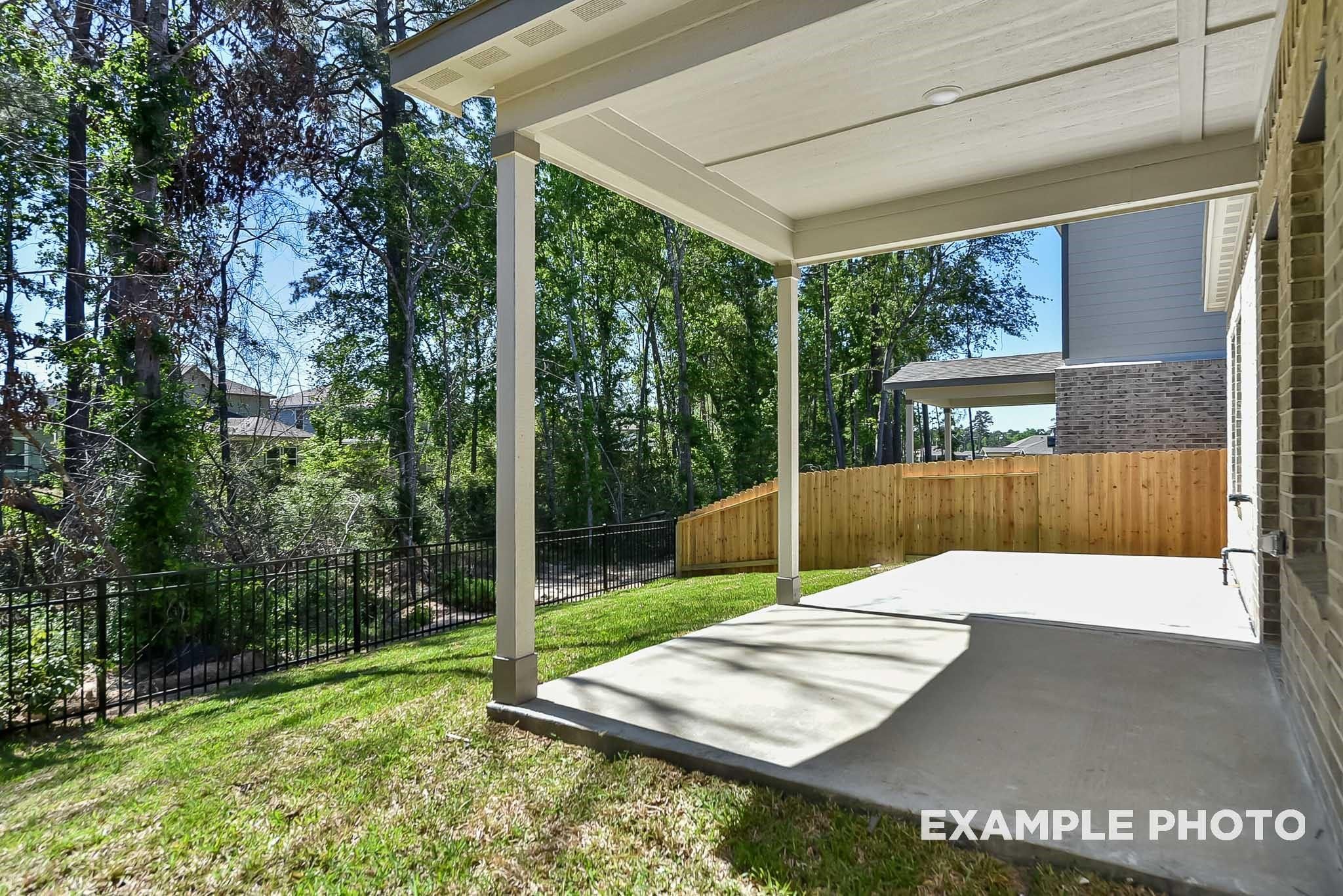 Covered concrete patio and private backyard in Caney Creek Place, Conroe, Texas, featuring The Blanco E floor plan.