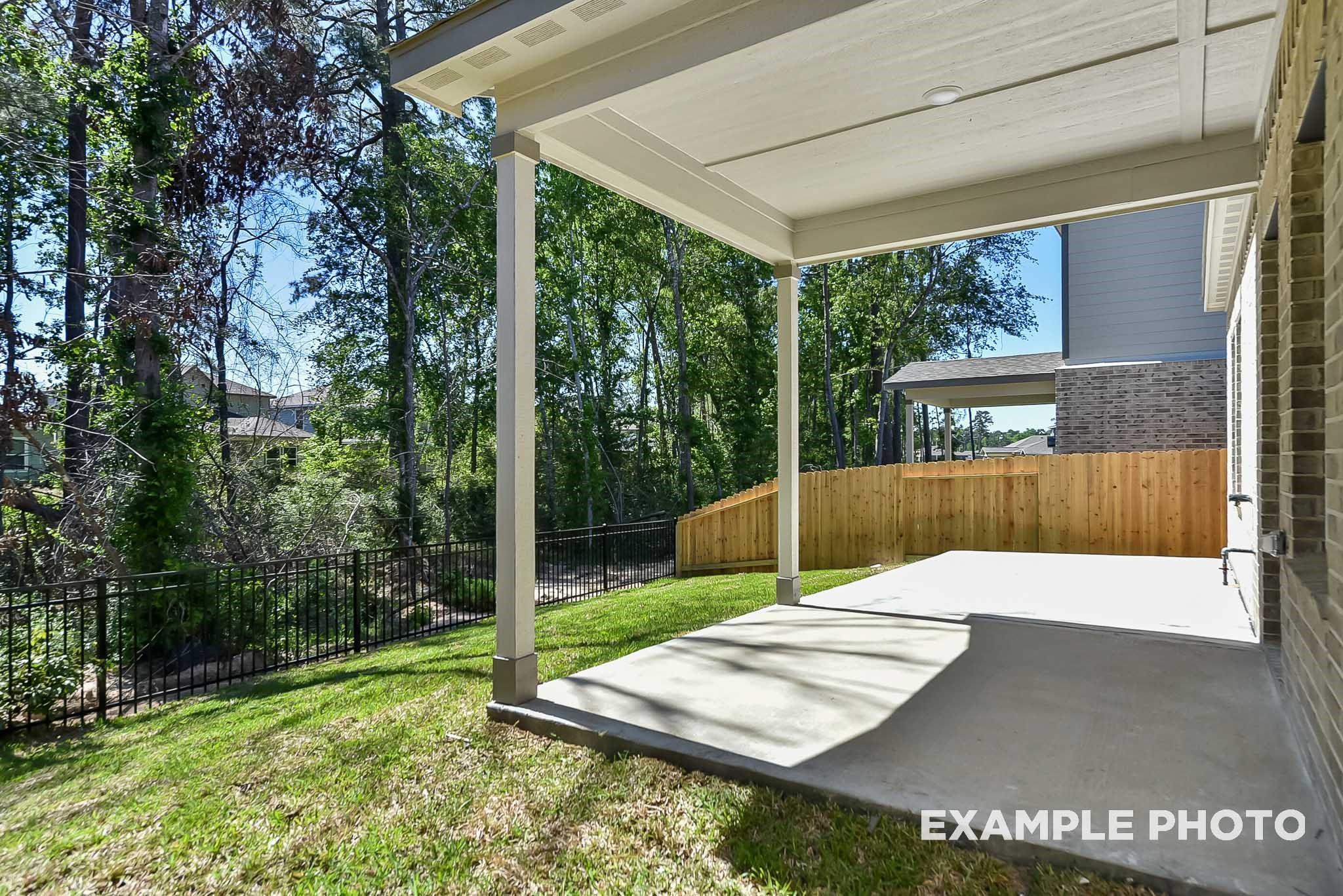 Covered concrete patio and private backyard in Caney Creek Place, Conroe, Texas, featuring The Blanco E floor plan.