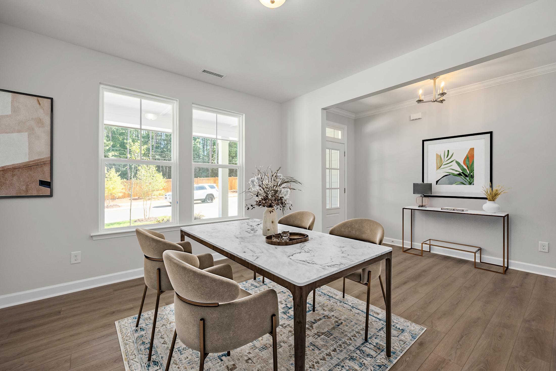 Spacious dining room in Ashland, Apex NC with marble-top table, upholstered chairs, hardwood floors and large windows