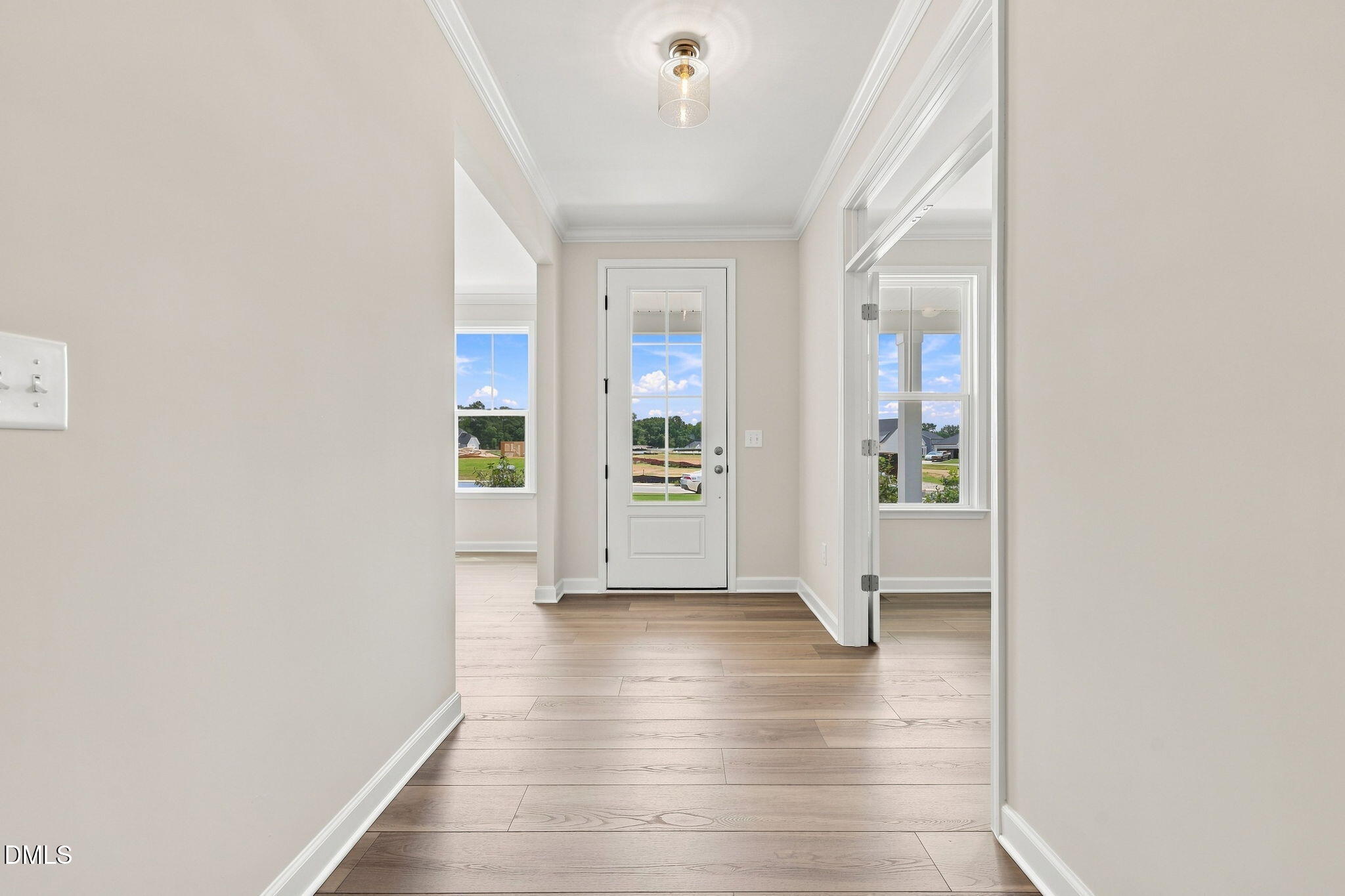 Bright entryway with hardwood floors and glass-paneled door in The Magnolia B floor plan at Retreat at North Main, Lillington.