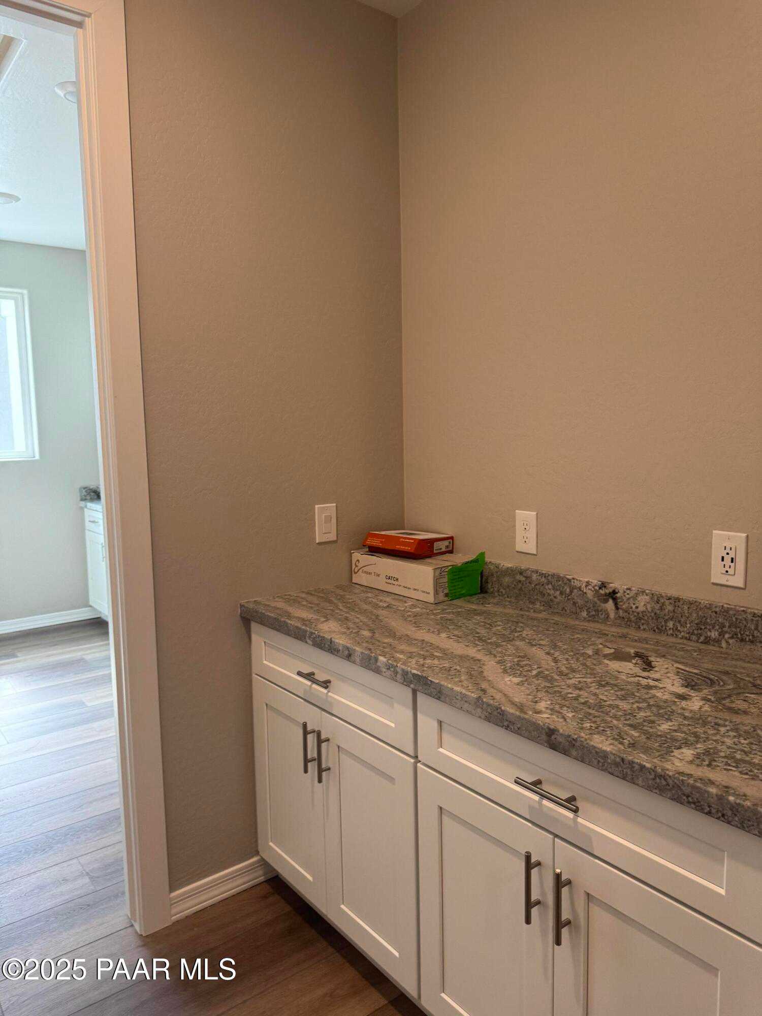 White shaker cabinets and granite countertops in utility area of Davidson Homes The Monarch A, Prescott, Arizona