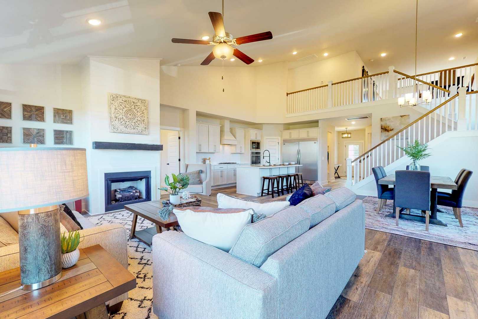 Open-concept living kitchen at Liberty Creek in Gallatin TN with gray sectional sofa, fireplace, hardwood floors, and staircase
