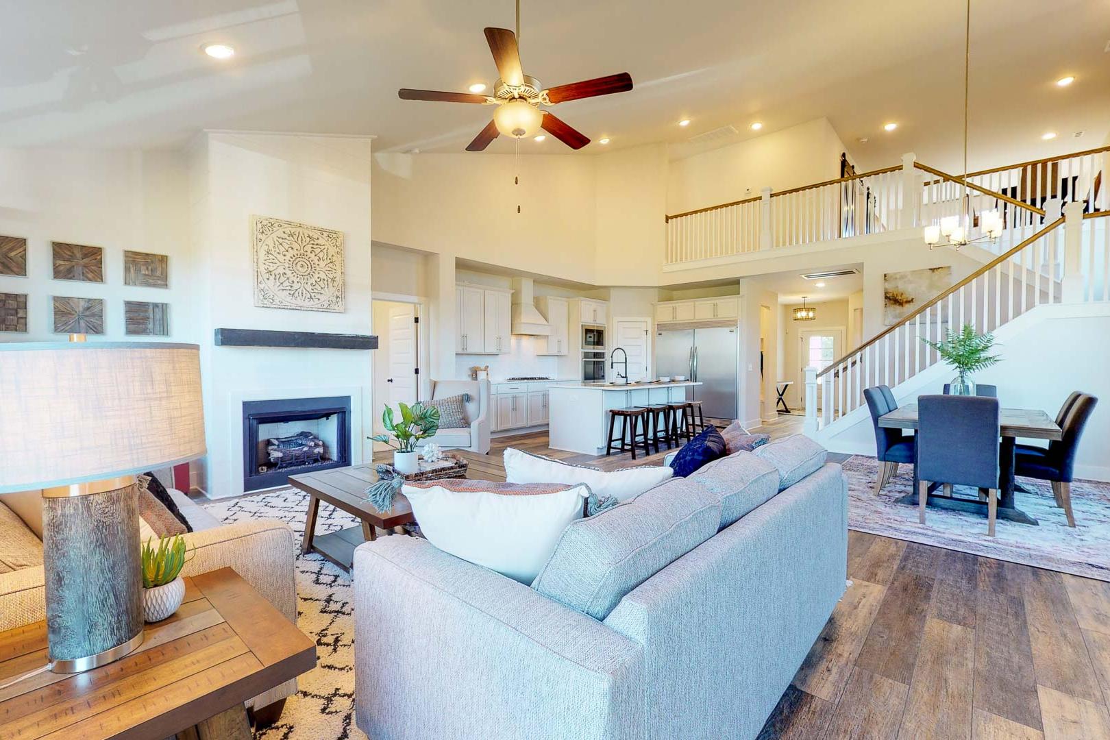 Open-concept living kitchen at Liberty Creek in Gallatin TN with gray sectional sofa, fireplace, hardwood floors, and staircase