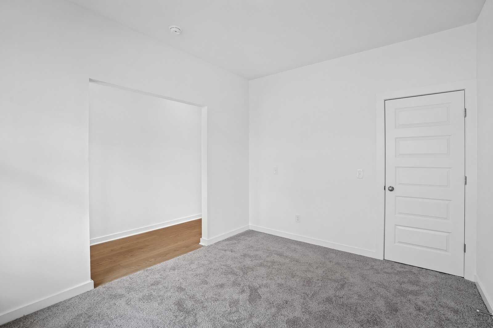 Bright secondary bedroom with gray carpet, white walls, and built-in closet in Davidson Homes The Logan B, White House, TN