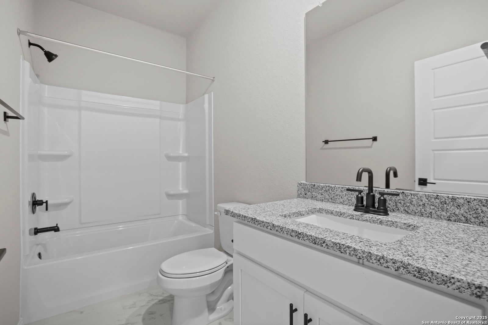 Modern bathroom featuring granite vanity, white tub-shower combo, and toilet in Davidson Homes The Daphne H, Seguin, Texas