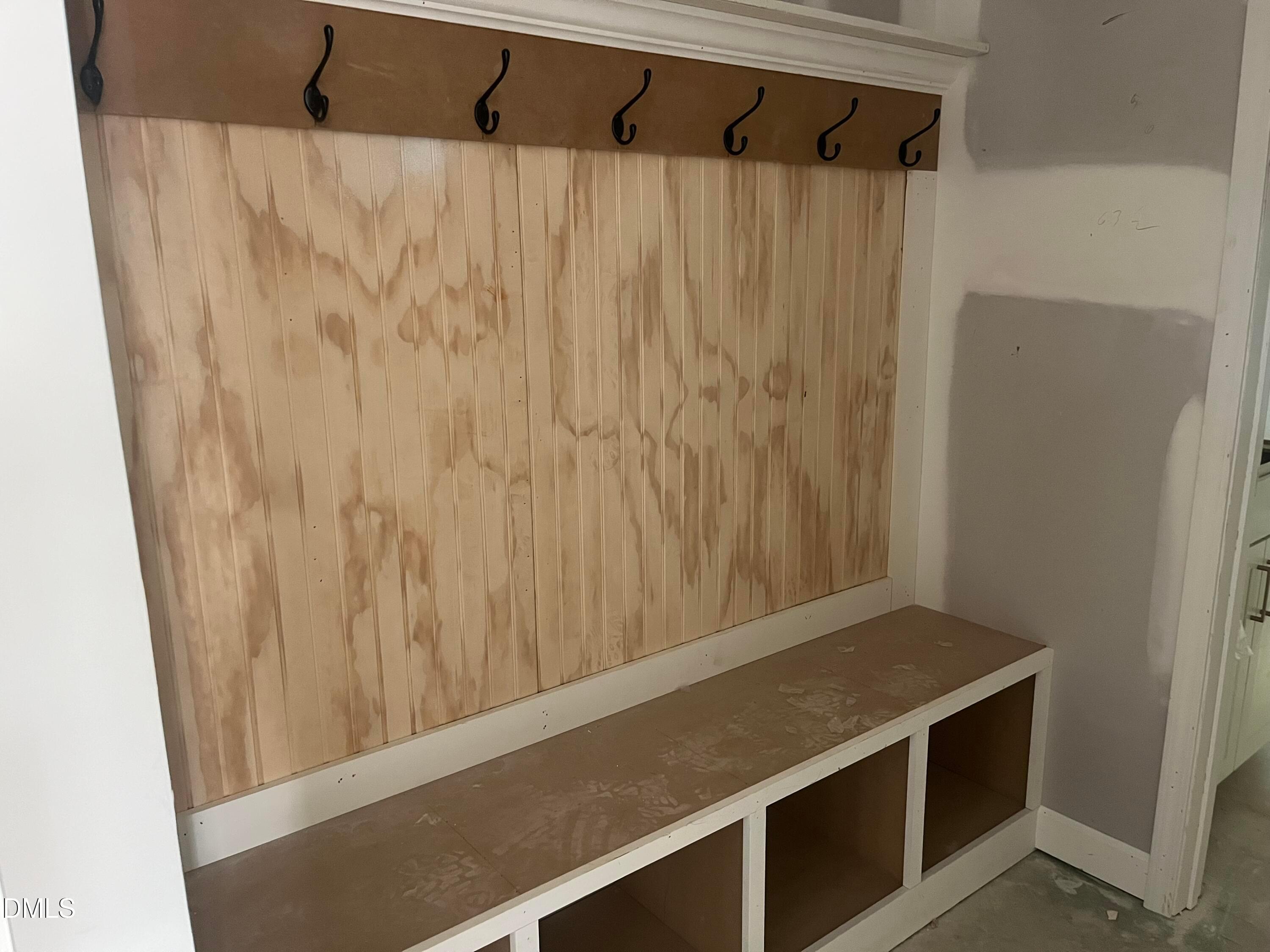 Rustic mudroom with slatted wood wall, coat hooks, built-in bench and storage cubbies in Davidson Homes Ashport G, Wake Forest, NC