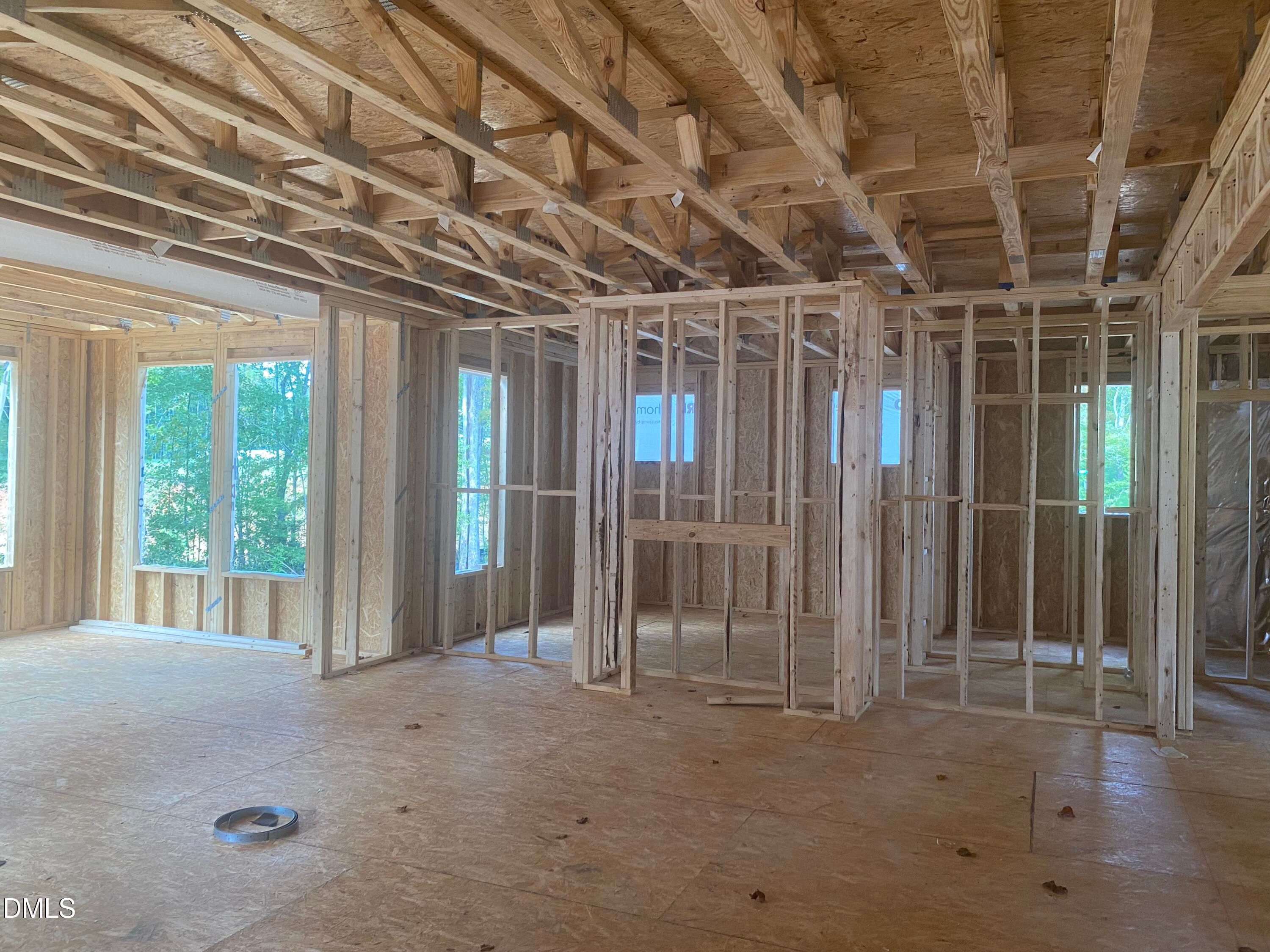 Spacious open framing with wooden studs, trusses, and large windows in Davidson Homes Crawford B, Laneridge Estates, Raleigh NC