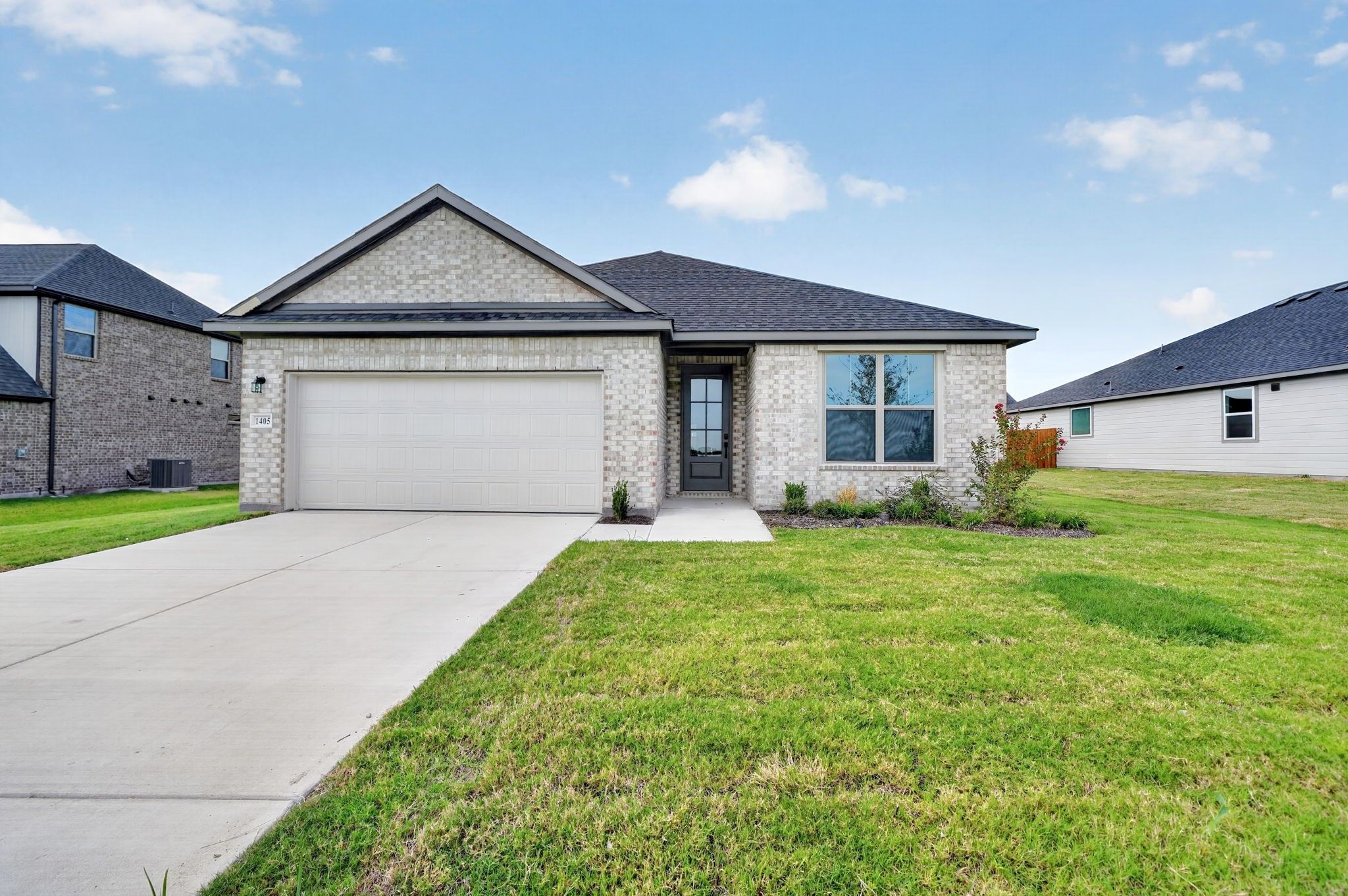 Single-story brick exterior with 2-car garage and landscaped front yard at Davidson Homes' The Holly F in Meadow Ridge Estates, Josephine, TX