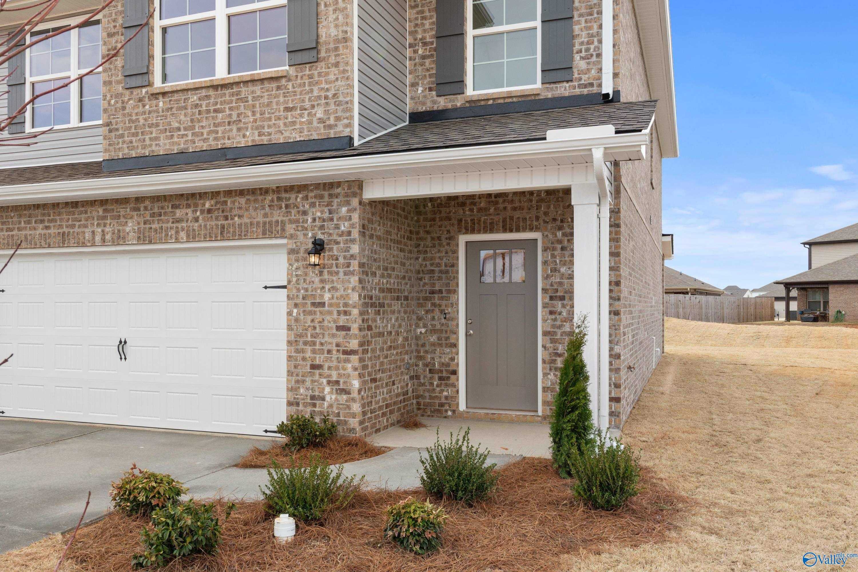 Two-story brick home with two-car garage, covered front porch, and landscaped entry in Walker's Hill, Meridianville, Alabama - The Aiken by Davidson Homes