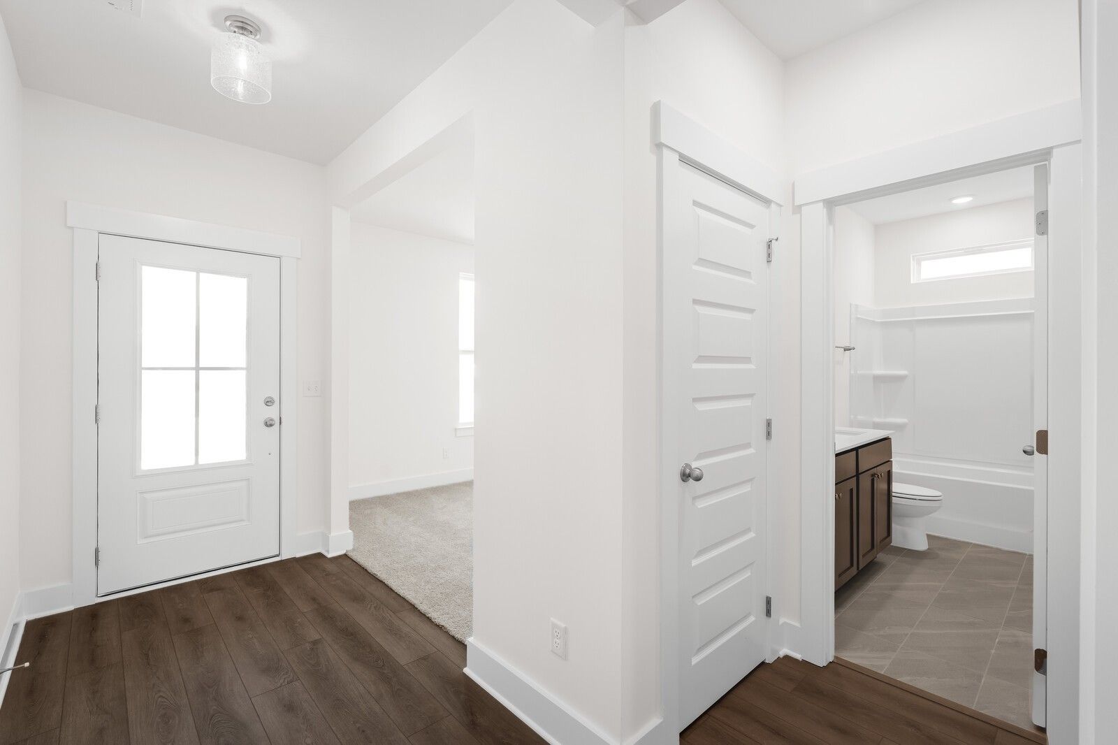 Bright foyer with glass-panel front door, hardwood floors, and full bath with tub in Davidson Homes Cottonwood E, Gallatin TN