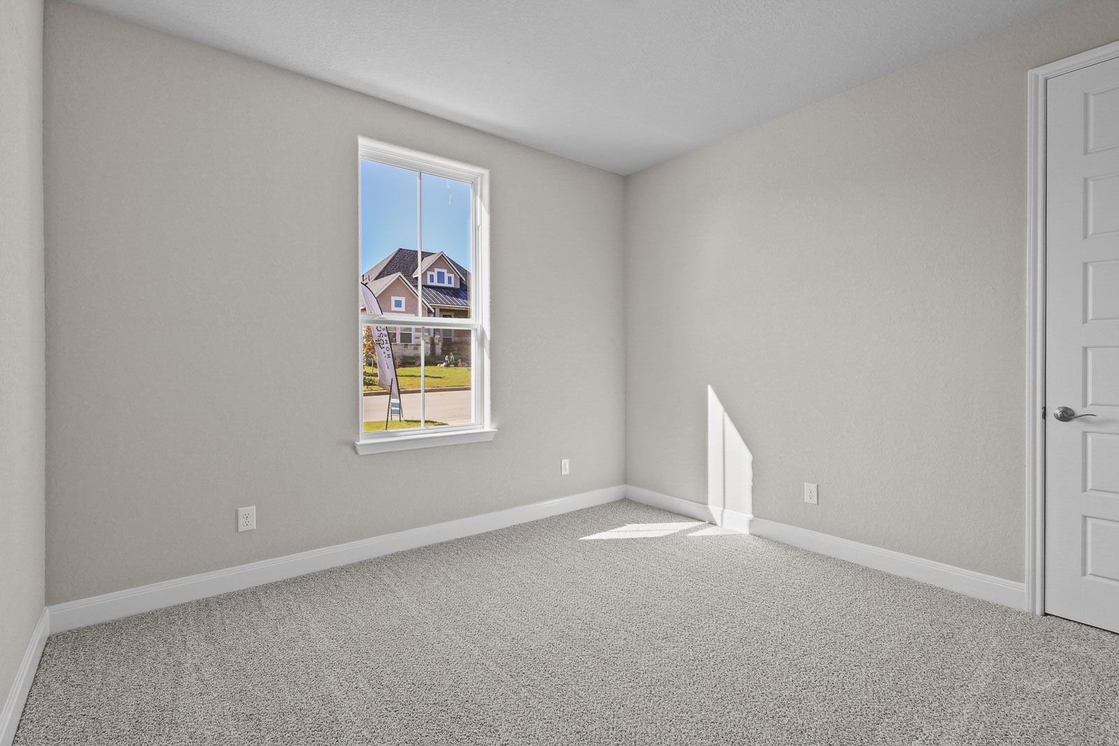 Spacious secondary bedroom in The Jennings F floor plan with neutral carpet, natural light, and classic interior finishes.