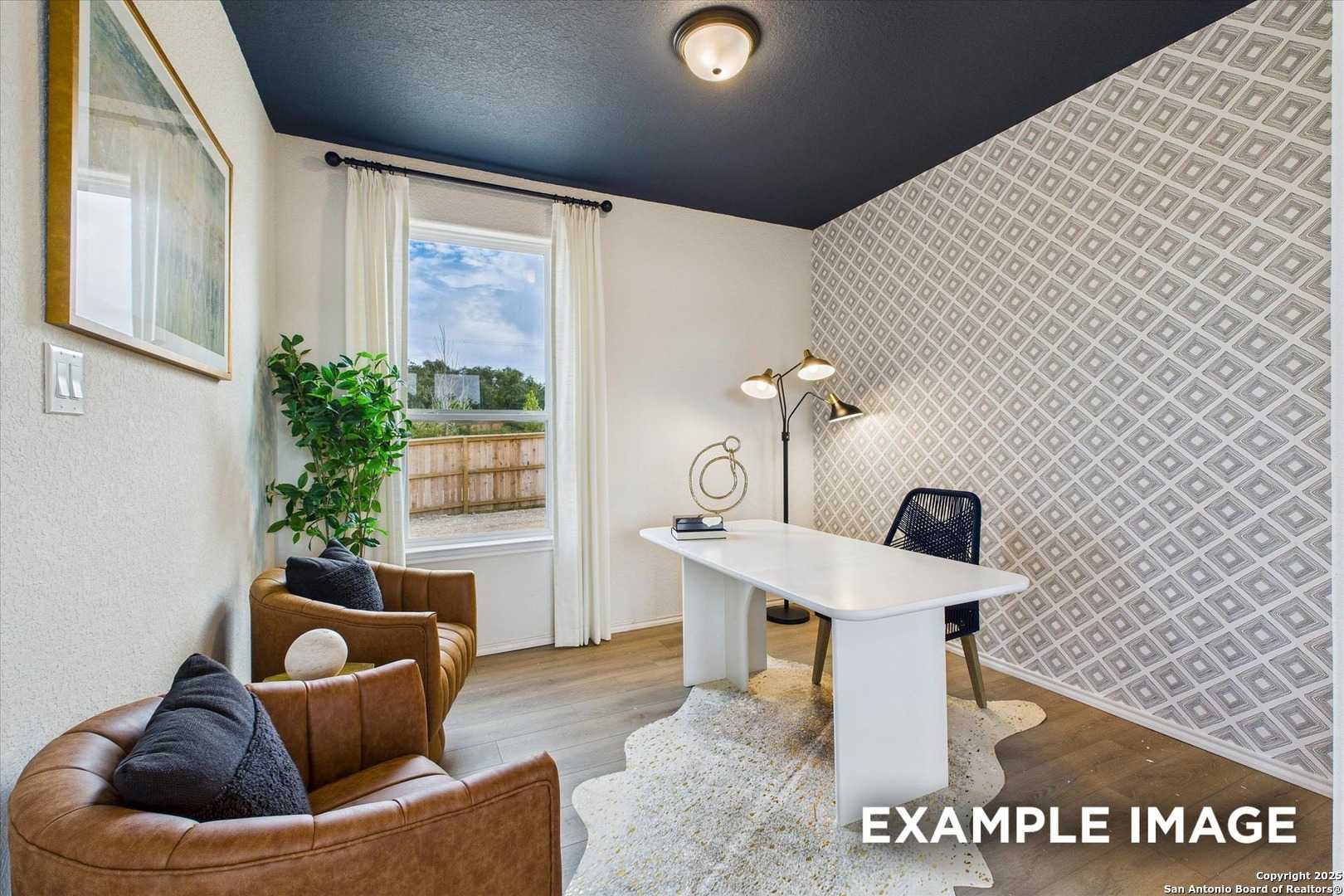 Cozy home office with navy ceiling, geometric wallpaper, white desk, leather chairs, and large window in Davidson Homes Florence C, San Antonio