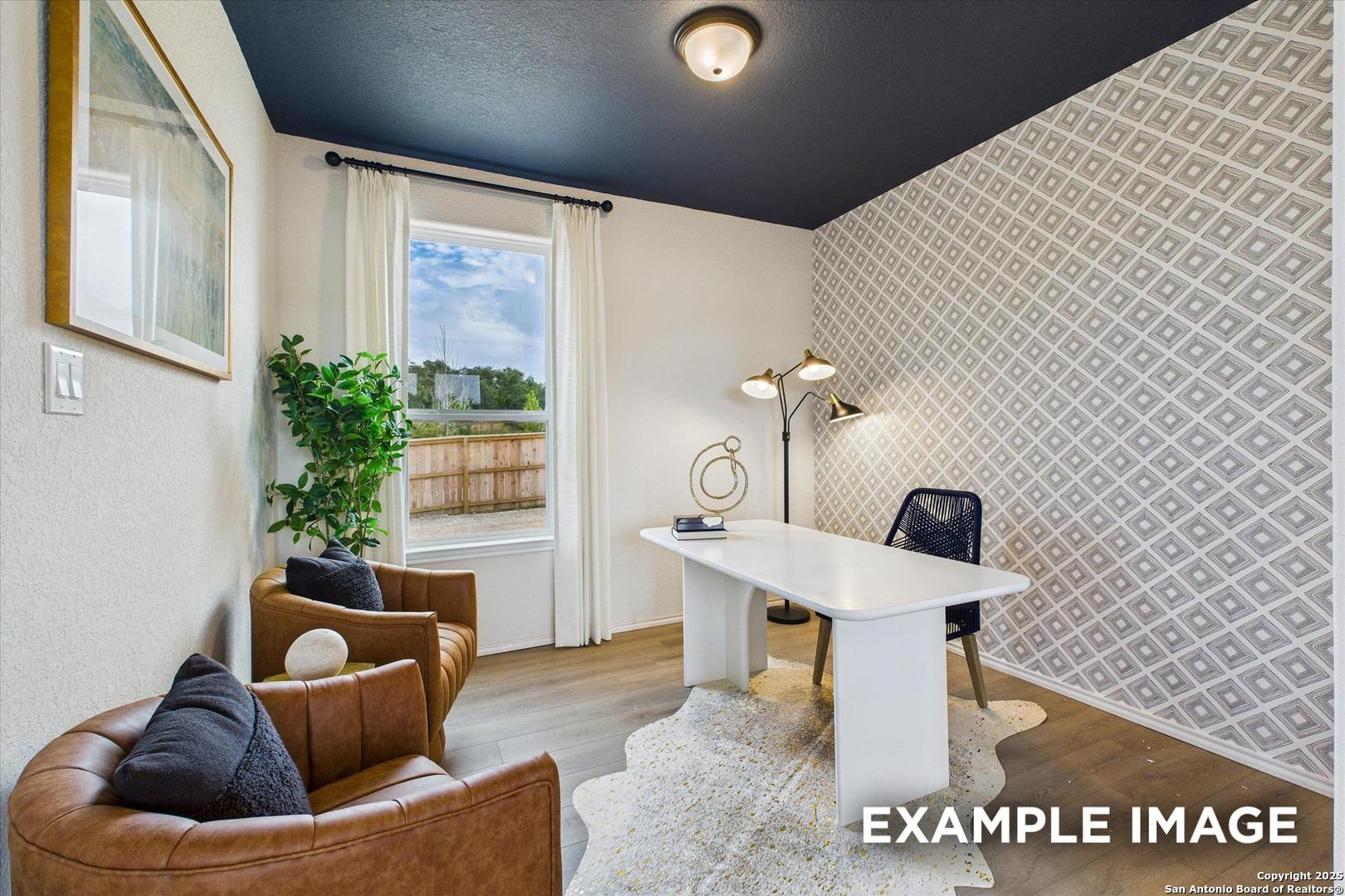 Cozy home office with navy ceiling, geometric wallpaper, white desk, leather chairs, and large window in Davidson Homes Florence C, San Antonio