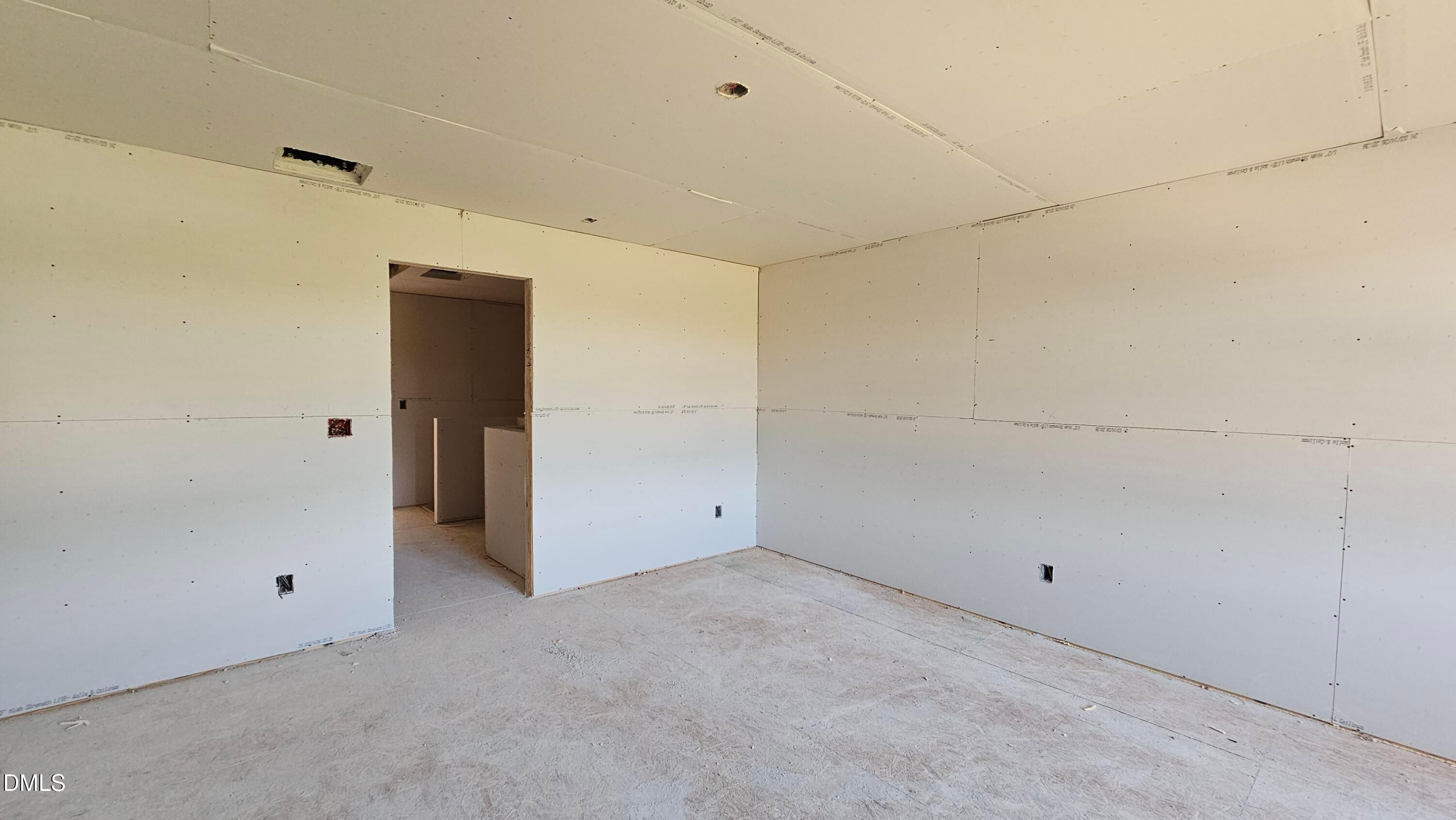 Unfinished bedroom with drywall installation in The Graham Interior floor plan at Springvale, Fuquay-Varina, NC.