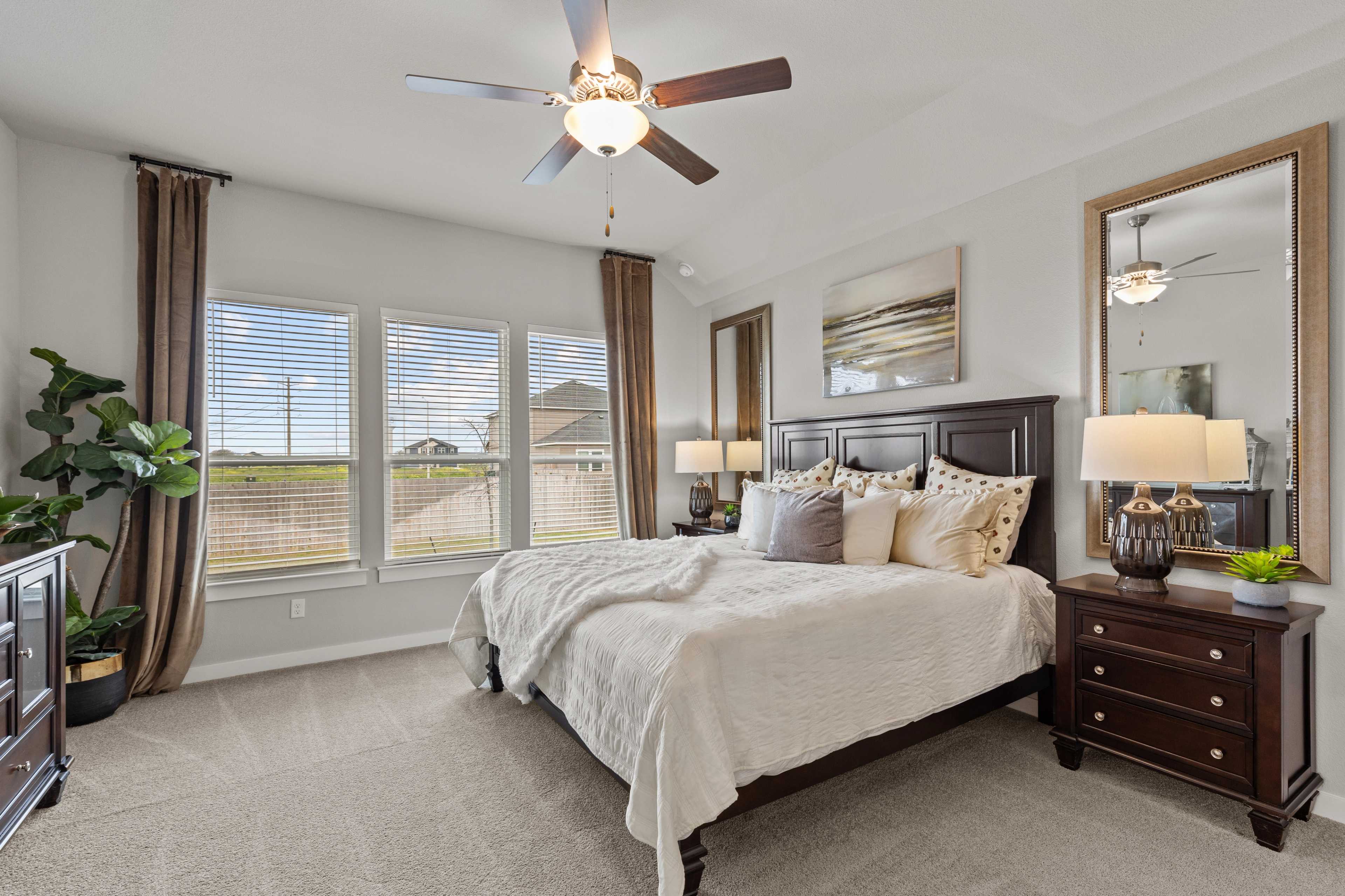 Spacious master bedroom at Hannah Heights in Seguin Texas with king bed, ceiling fan and large windows