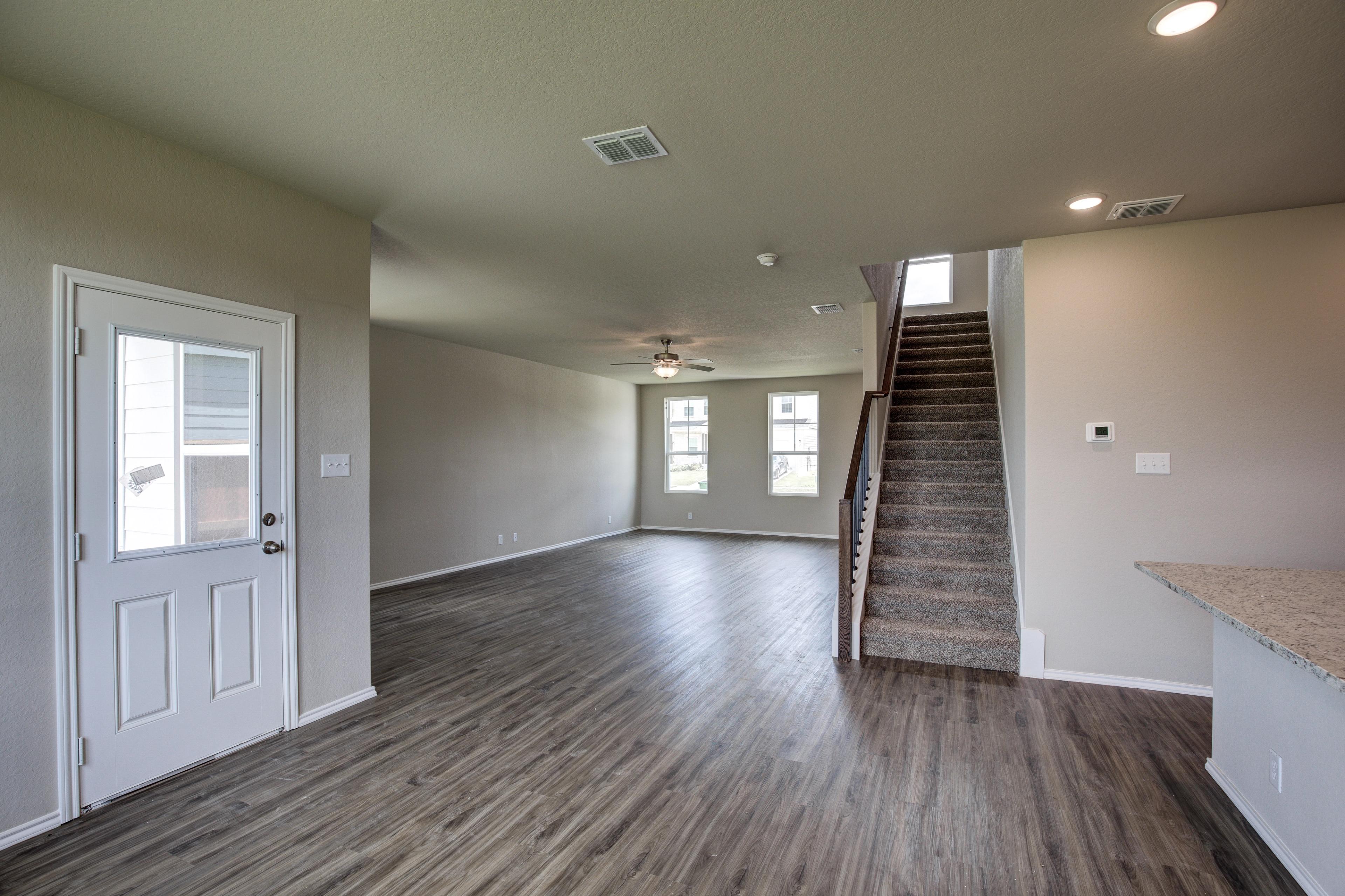 Spacious open entryway in The Murray G two-story home featuring hardwood floors, central carpeted staircase, and kitchen counter