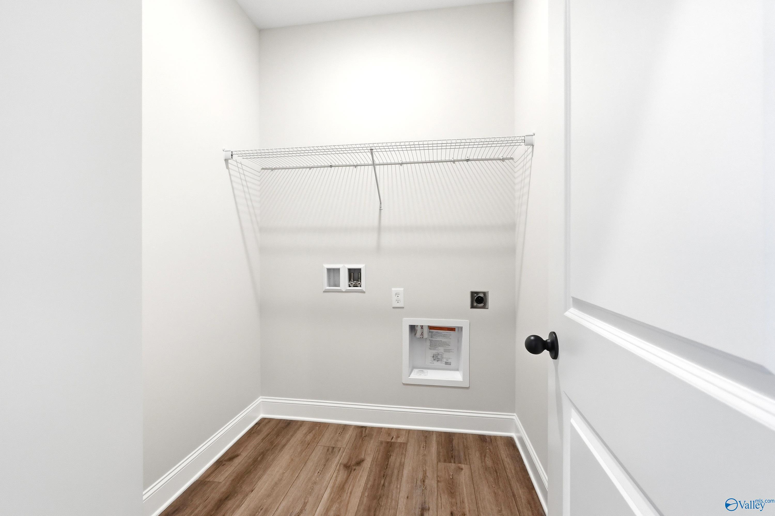 Laundry room with wire shelving and utility hookups in The Daphne floor plan by Davidson Homes in Hazel Green, Alabama.