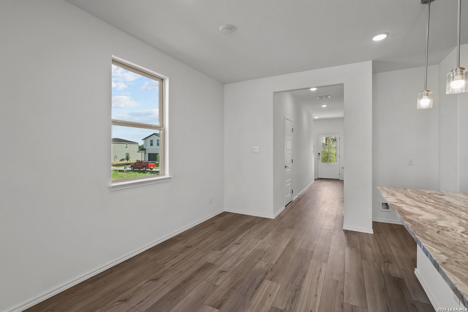 Bright dining area with wood-look flooring in The Brazos B floor plan by Davidson Homes in Agave, San Antonio, Texas.
