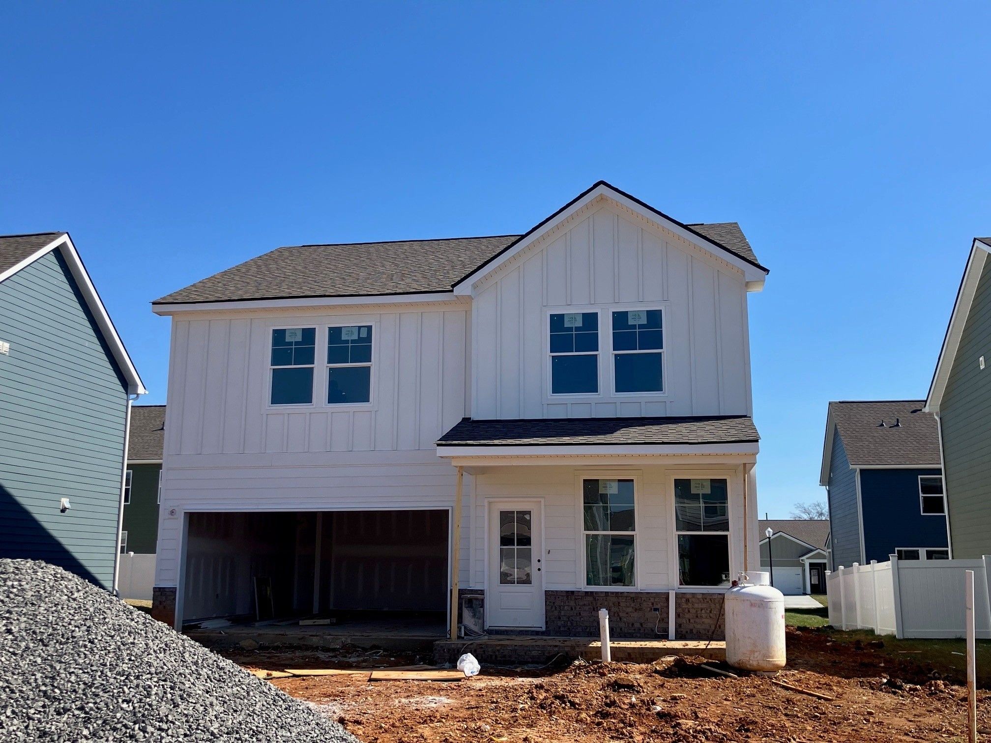 Two-story white board-and-batten home with open 2-car garage in Sage Farms, White House, Tennessee - Davidson Homes The Logan C