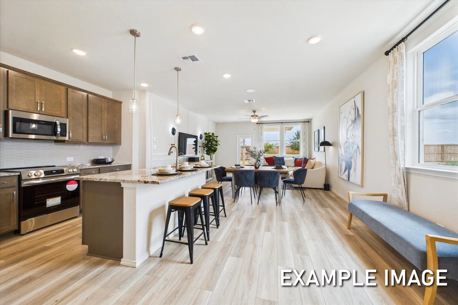 Open-concept kitchen and living area in The Brazos E floor plan by Davidson Homes in Heartland, Texas.