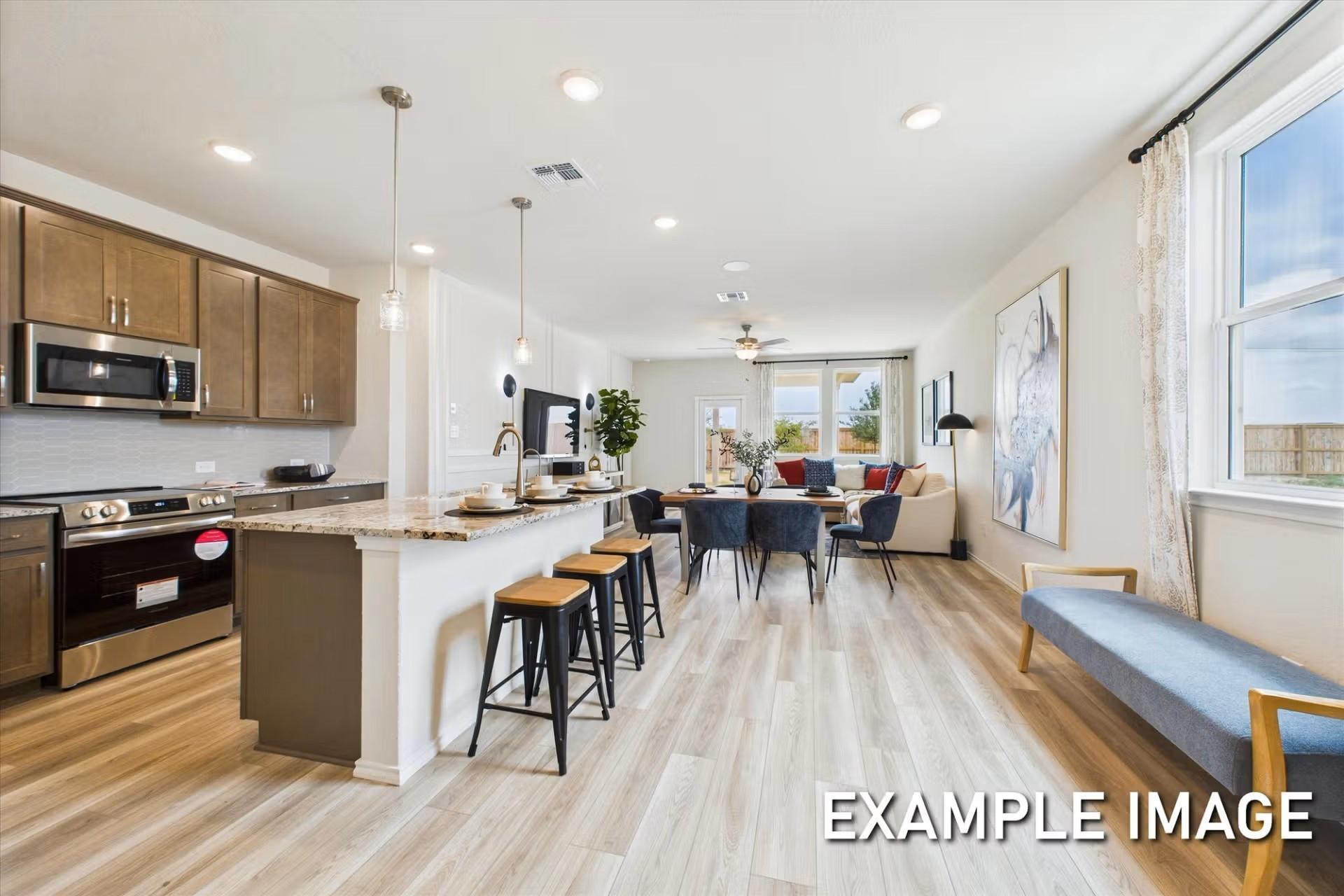Open-concept kitchen and living area in The Brazos E floor plan by Davidson Homes in Heartland, Texas.